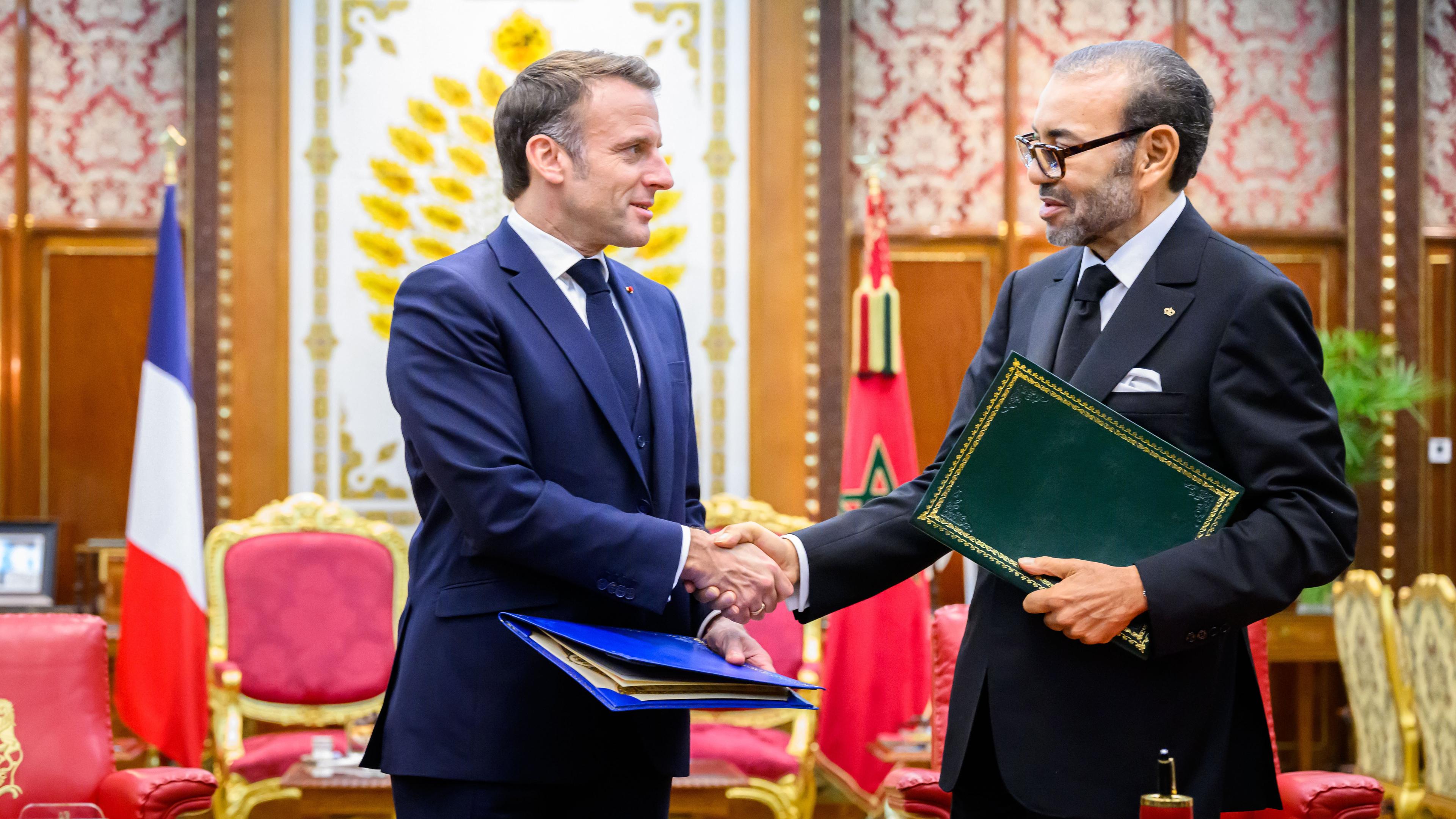 König Mohamed VI. von Marokko schüttelt dem französischen Präsidenten Emmanuel Macron die Hand.