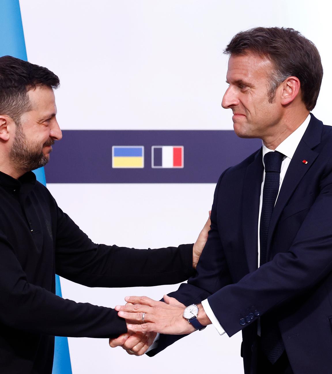 Der ukrainische Präsident Wolodymyr Selenskyj (l) schüttelt dem französischen Präsidenten Emmanuel Macron im Elysee-Palast während einer gemeinsamen Pressekonferenz die Hand. 