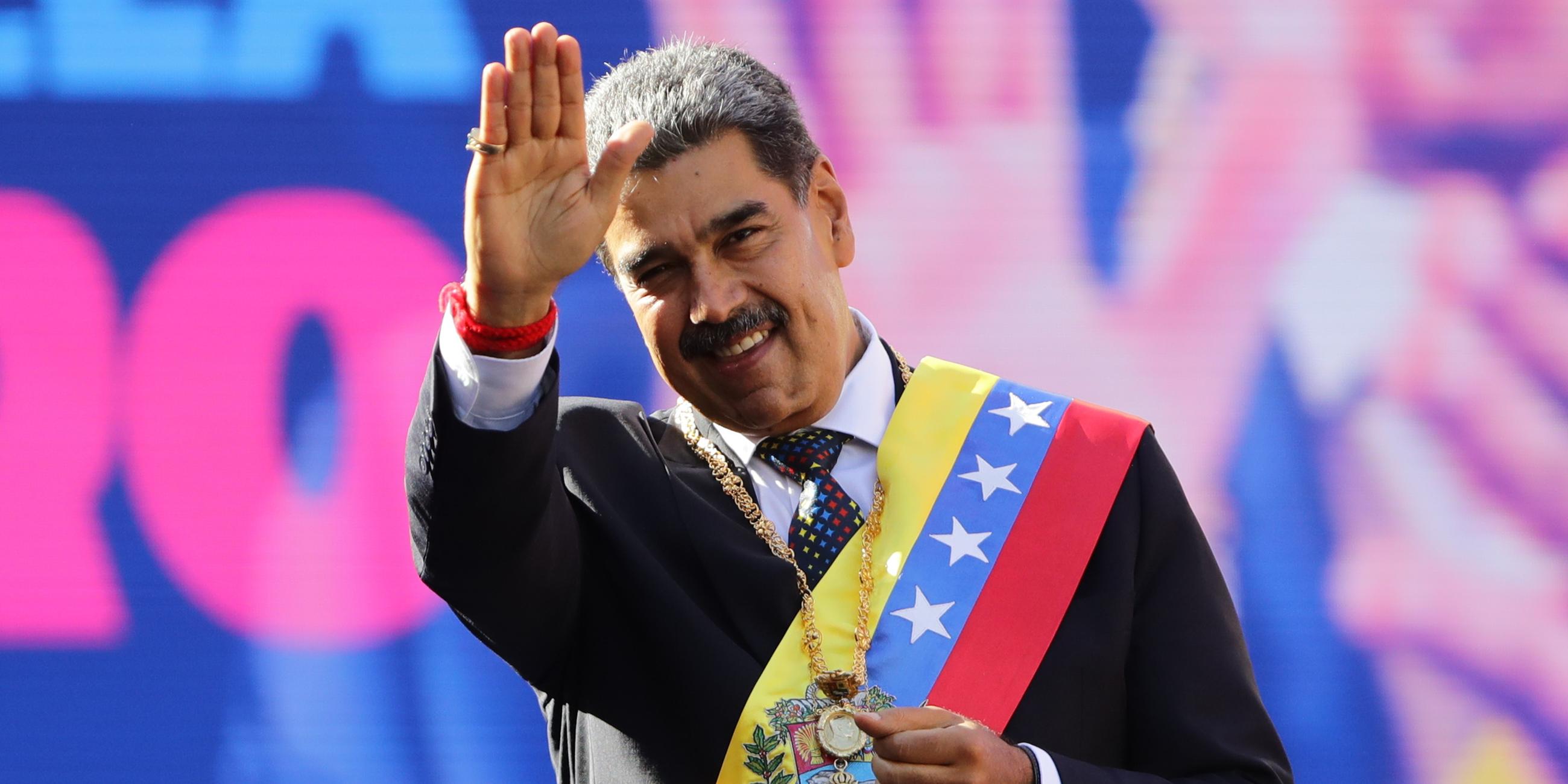 Der venezolanische Präsident Maduro hebt nach seiner Vereidigung die Hand und grüßt das Publikum