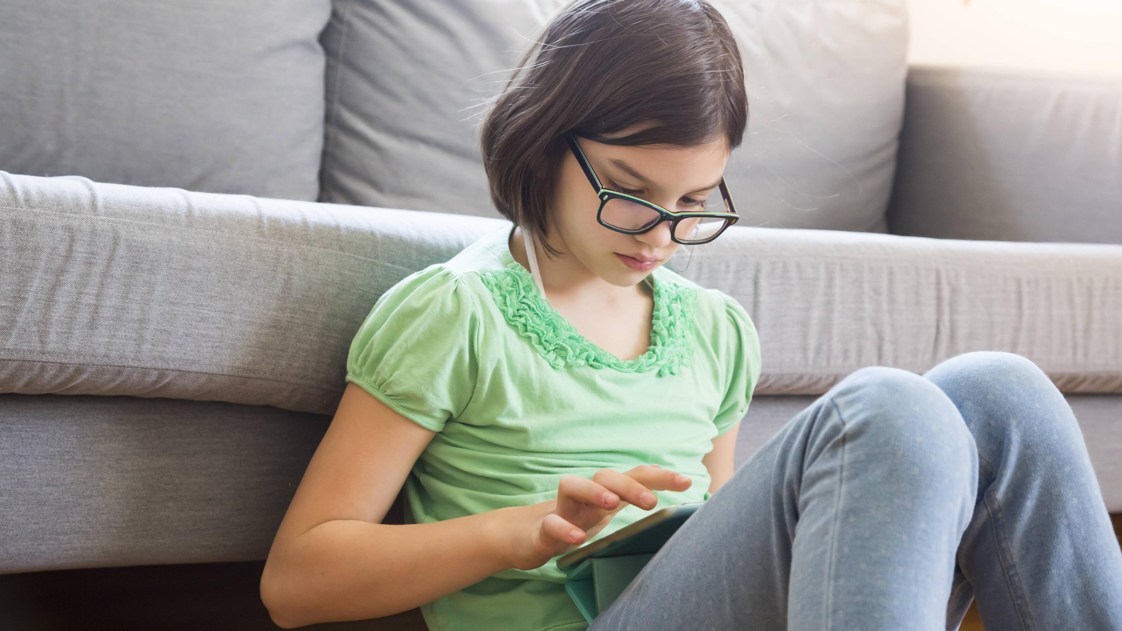 Mädchen mit Brille am Tablet