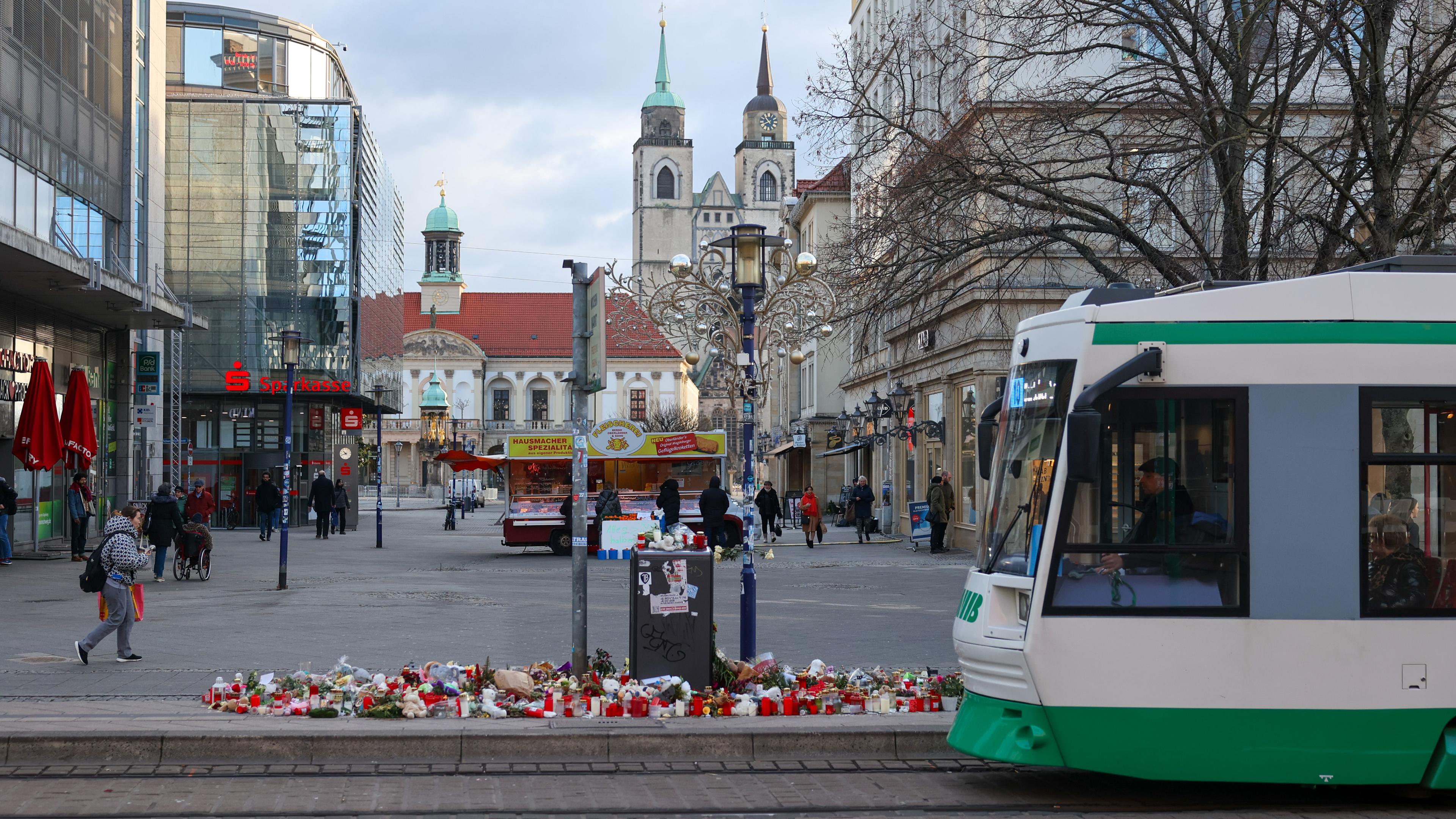 Die Magdeburger Innenstadt, in der eine Straßenbahn an einem Blumenmeer vorbeifährt