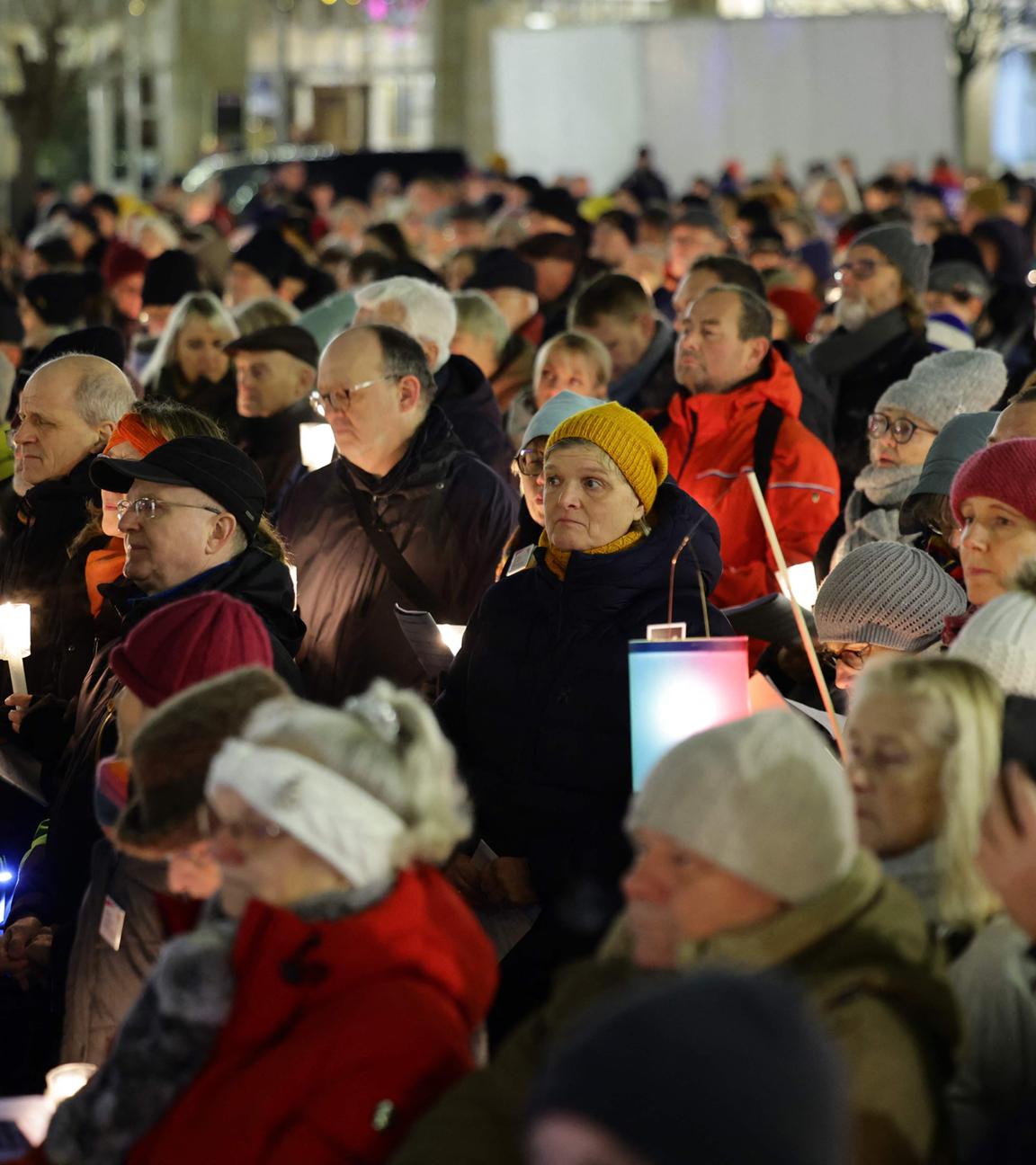 Menschen halten Kerzen und singen bei der Gedenkveranstaltung „Magdeburg singt für eine weltoffene Stadt“ für die Opfer des Weihnachtsmarktanschlags auf dem alten Marktplatz in Magdeburg