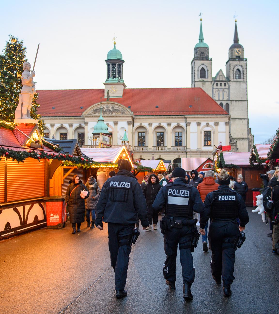 Drei Polizisten gehen über den Magdeburger Weihnachtsmarkt