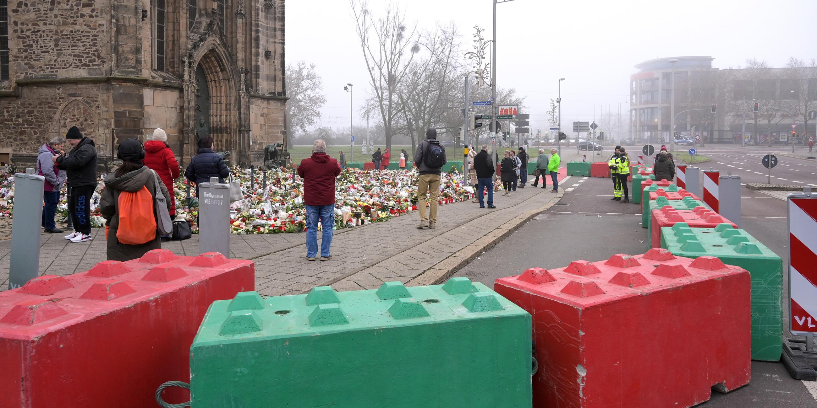 Menschen stehen vor der Johanniskirche, um den Opfern des Anschlags zu gedenken