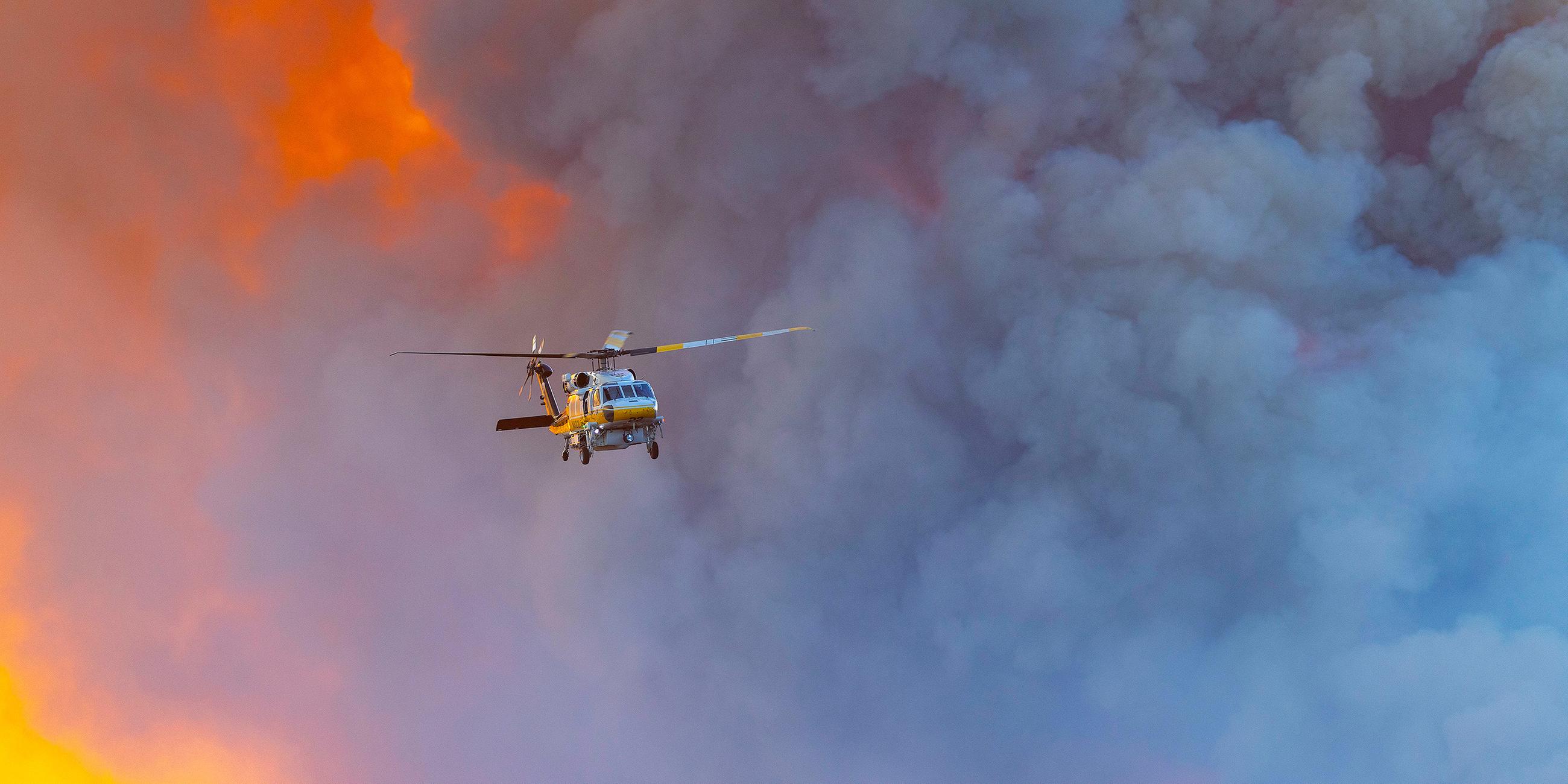 Ein Hubschrauber fliegt durch die Rauchschwaden des Franklin Fire in Malibu