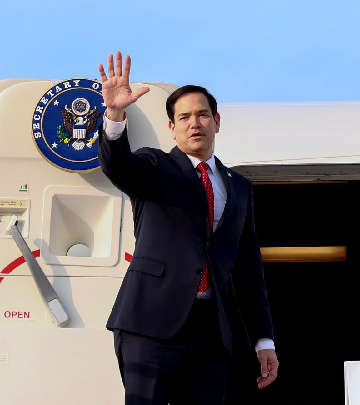 US-Außenminister Marco Rubio winkt, während er ein Flugzeug besteigt, das nach Abu Dhabi fliegt.