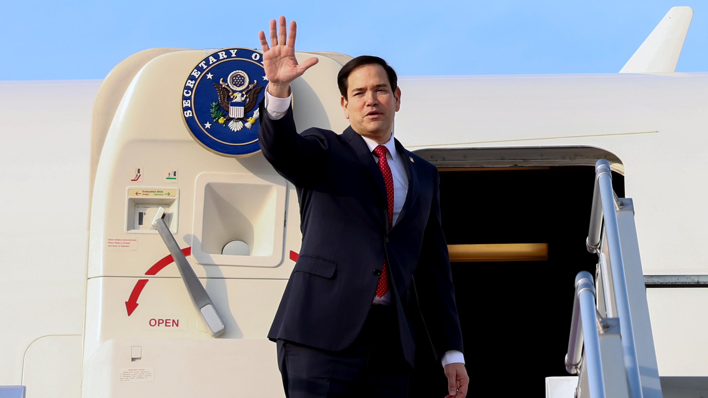 US-Außenminister Marco Rubio winkt, während er ein Flugzeug besteigt, das nach Abu Dhabi fliegt.