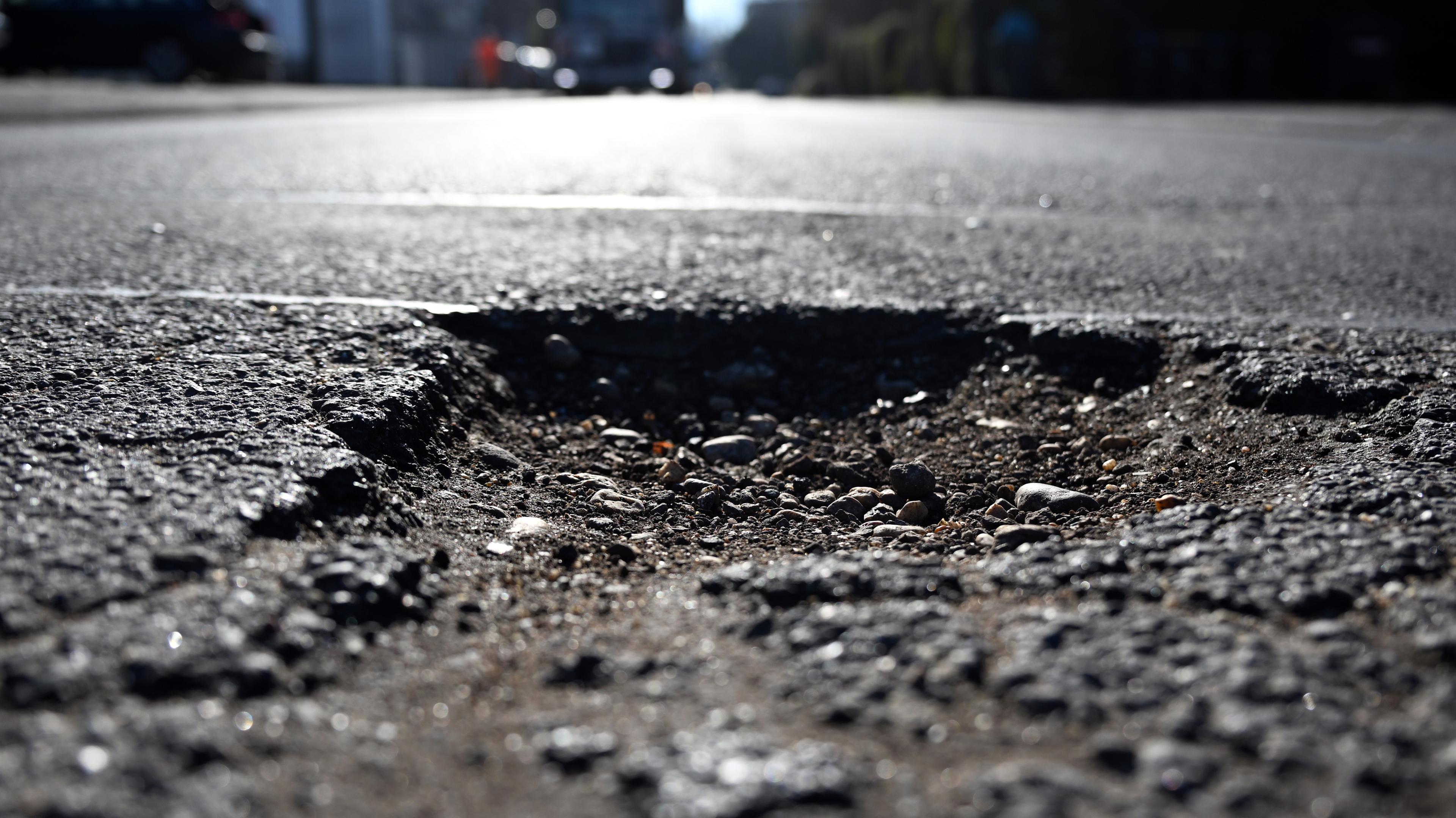 Ein Schlagloch auf einer deutschen Straße.