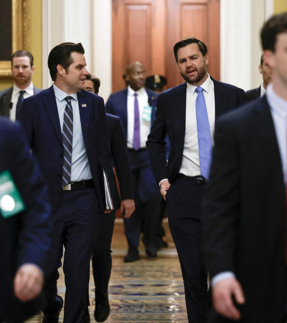 Mehrere Männer im Anzug laufen im US-Kongress auf die Kamera zu, in der Mitte sind links Matt Gaetz und rechts JD Vance zu sehen.