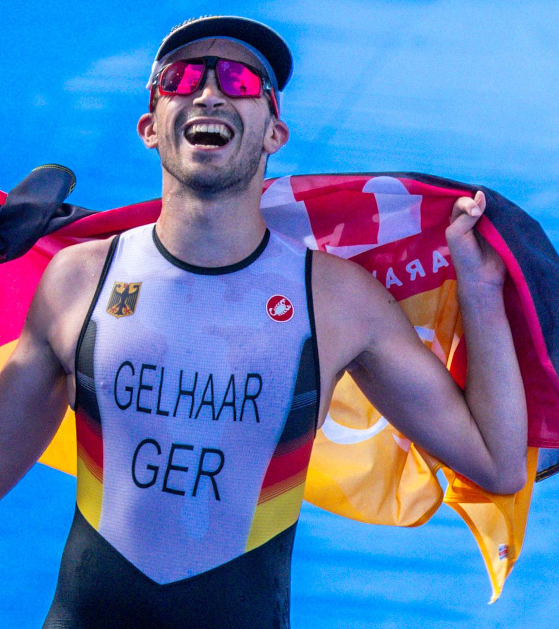 Max Gelhaar läuft grinsend mit Deutschland-Flagge in den Händen