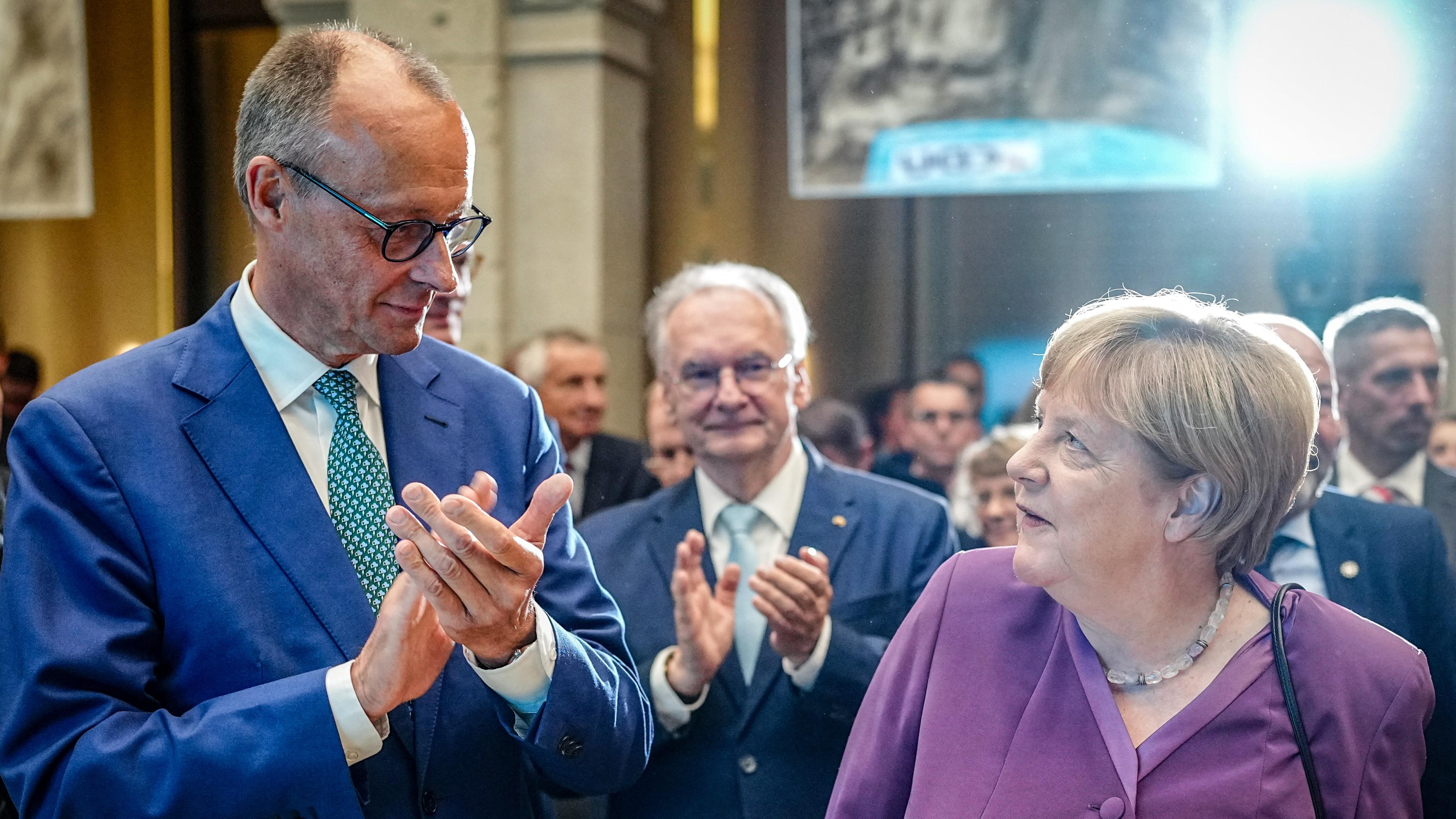 Angela Merkel und Friedrich Merz, CDU-Bundesvorsitzender und Unionsfraktionsvorsitzender, nehmen am Berliner Gespräch Spezial zum 70. Geburtstag der früheren Bundeskanzlerin teil.