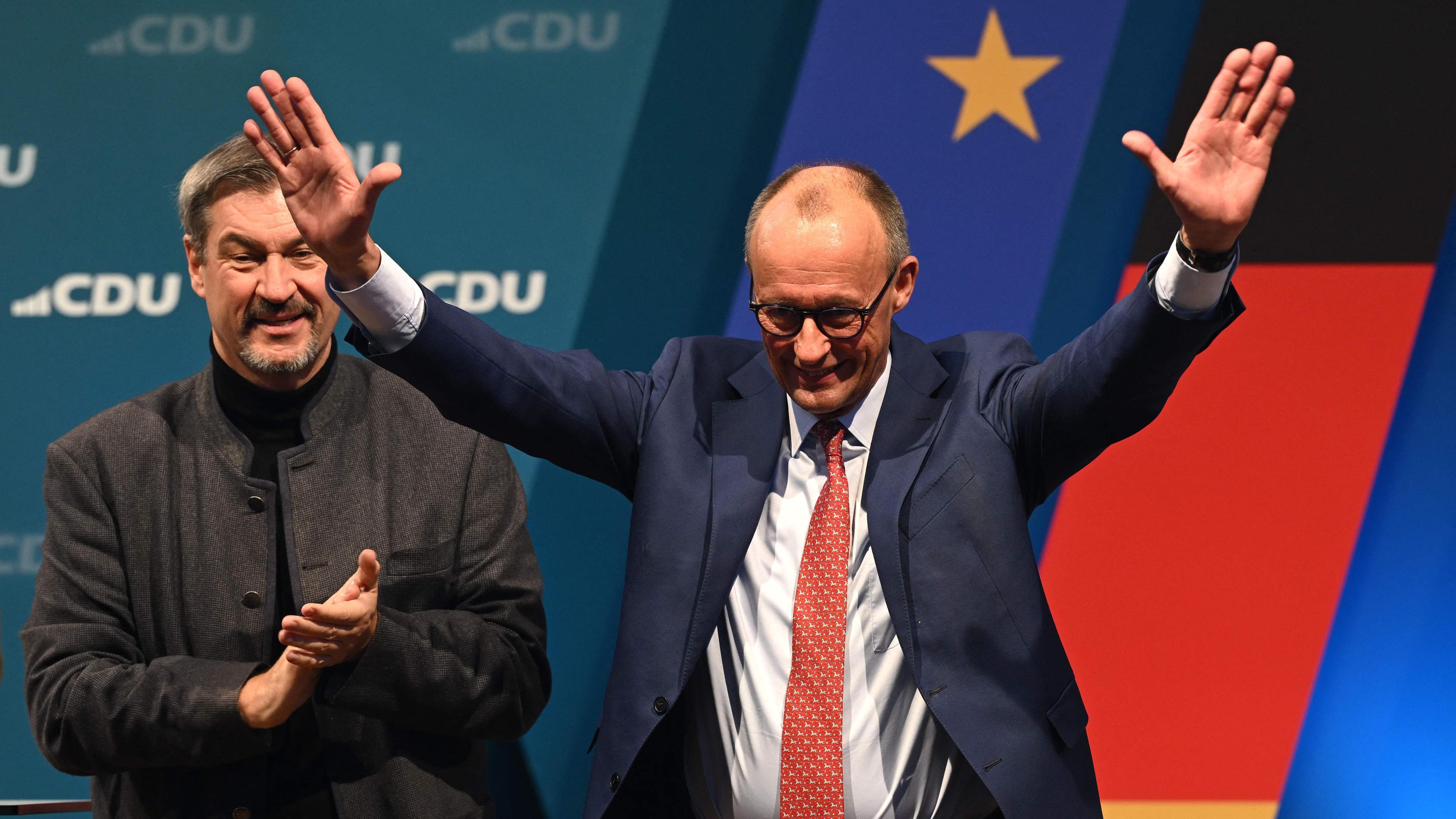 The leader and top candidate for Chancellor of Germany's Christian Democratic Union (CDU) Friedrich Merz (R) waves the audience 