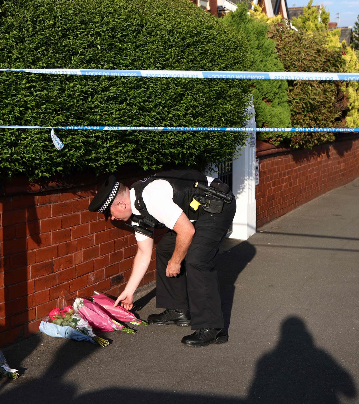 Ein Polizeibeamter legt am 29.072024 nach einem Messerangriff in der Hart Street in Southport, Nordwestengland, Blumen nieder.