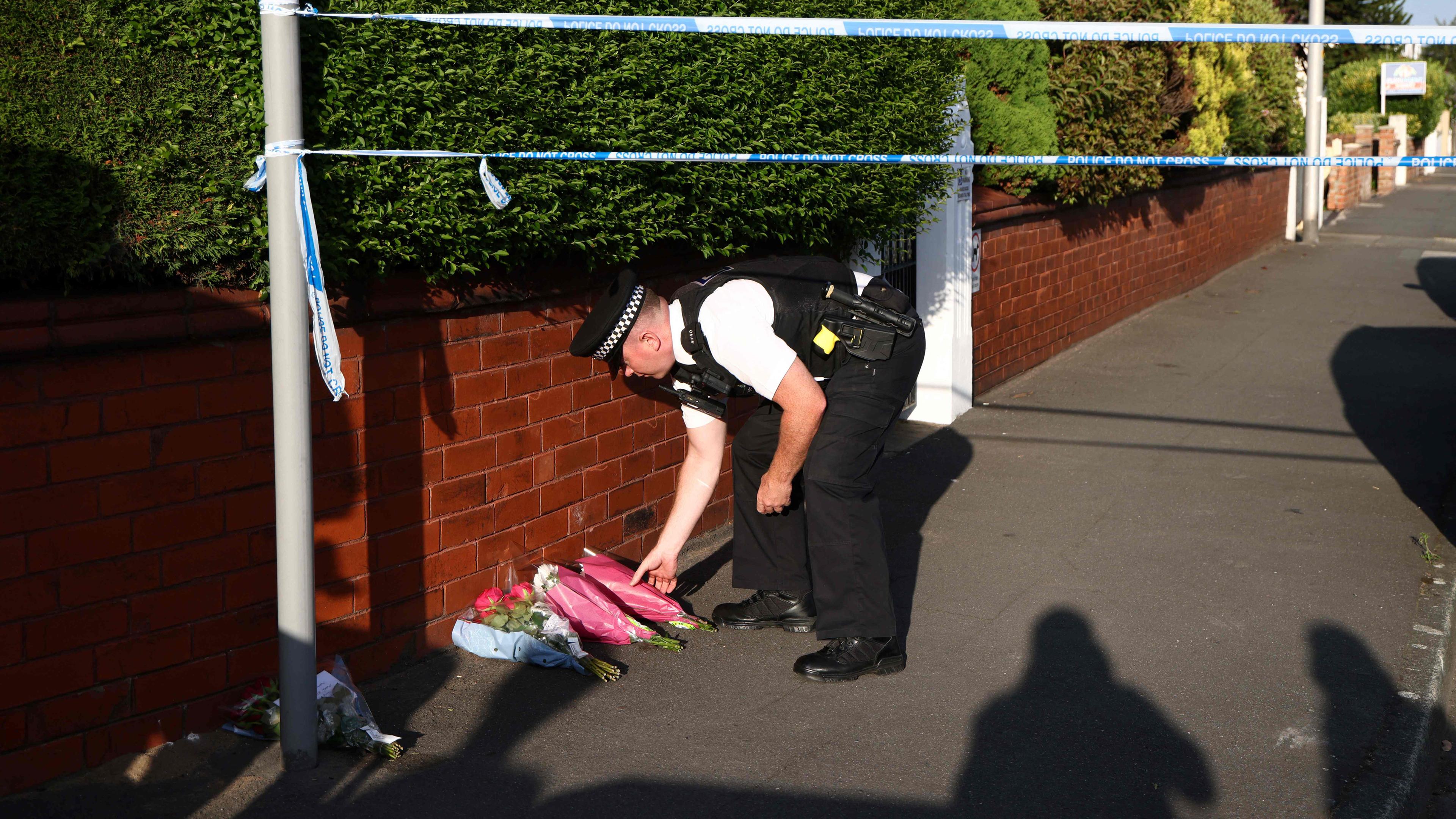 Ein Polizeibeamter legt am 29.072024 nach einem Messerangriff in der Hart Street in Southport, Nordwestengland, Blumen nieder.
