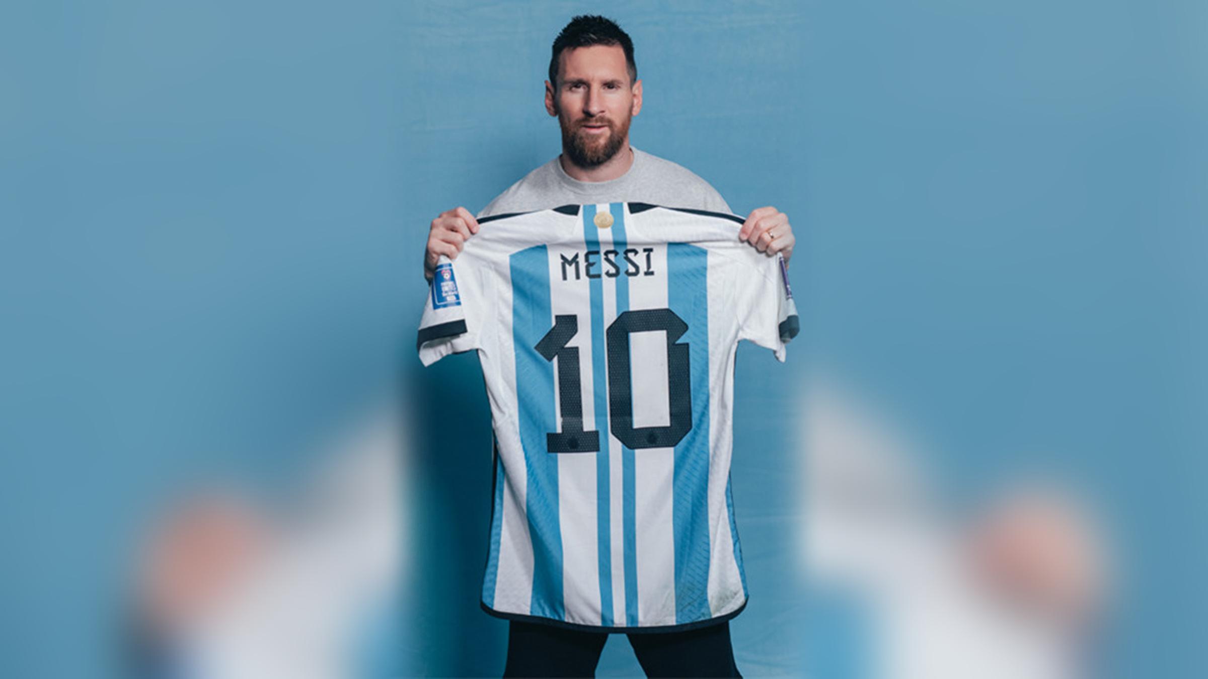 Lionel Messi hält ein argentinisches Fußballtrikot mit seiner Nummer 10