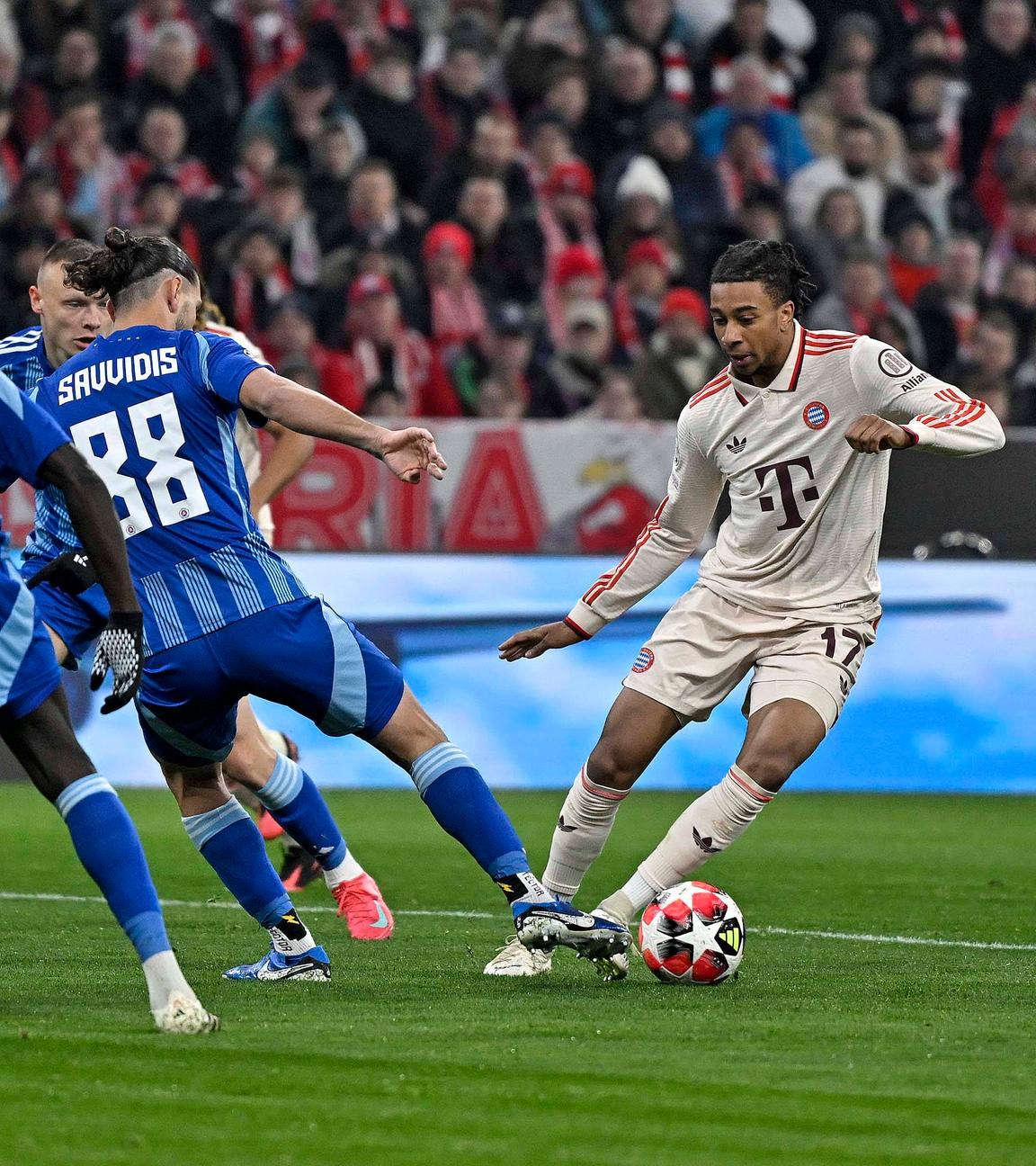 Sharani Zuberu (Slovan Bratislava), Kyriakos Savvidis (Slovan Bratislava) gegen Michael Olise (FC Bayern München).