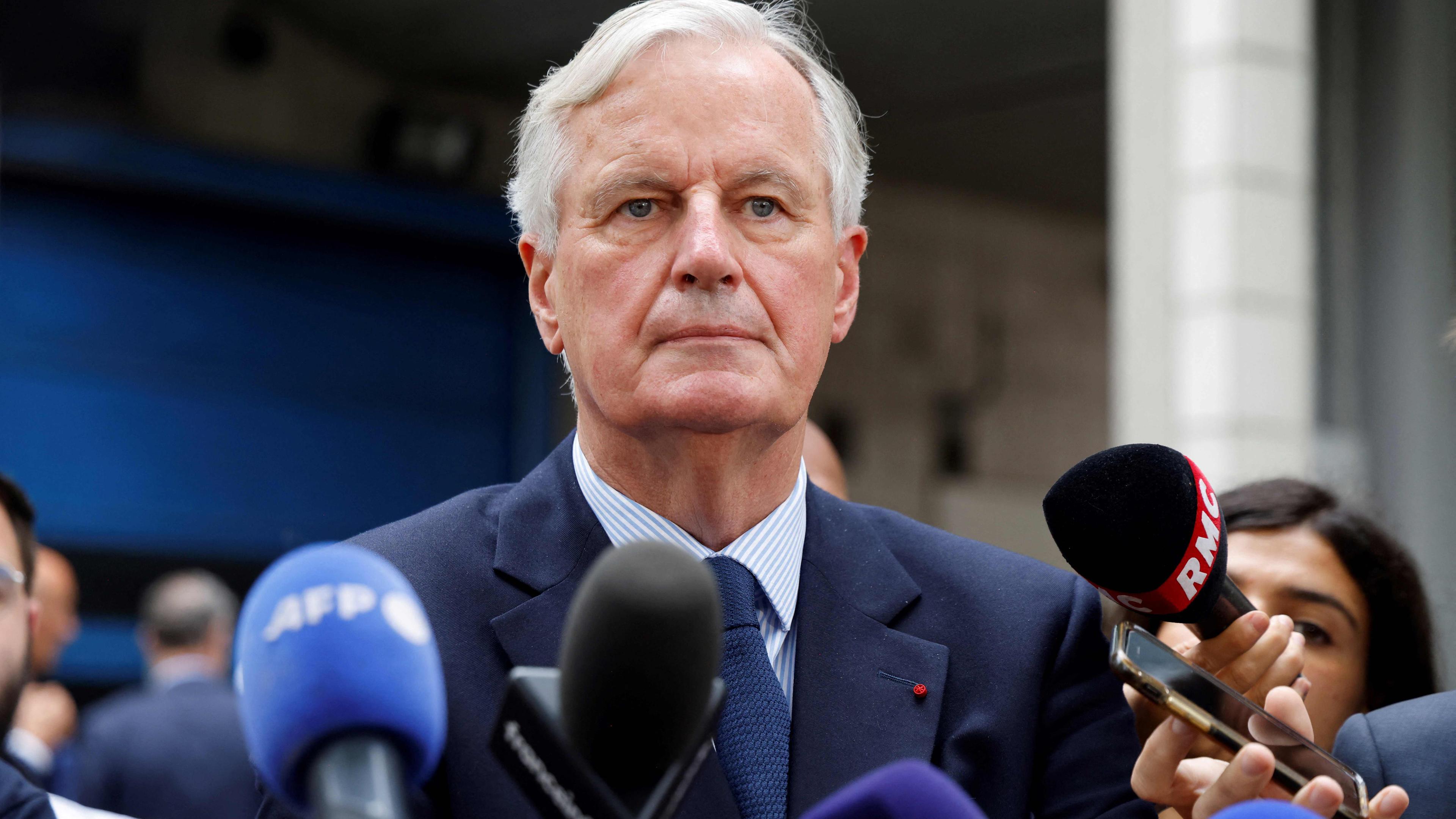 Michel Barnier - Premierminister Frankreichs mit Mikrofonen bei einer Pressekonferenz.