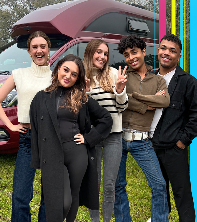 Emma, Sofia, Toni, Malik und Chinedu stehen vor ihrem Camper auf einer Wiese