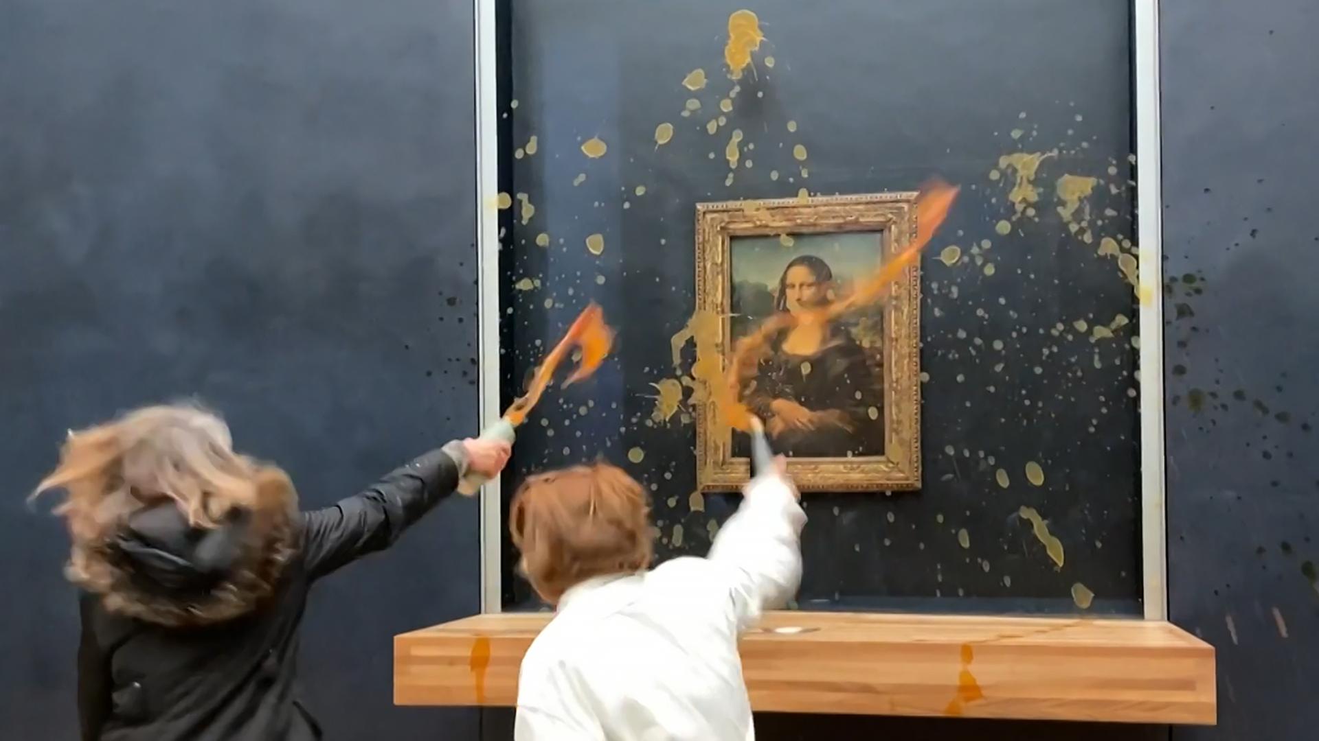 Zwei Frauen beschütten die "Mona Lisa" mit Suppe
