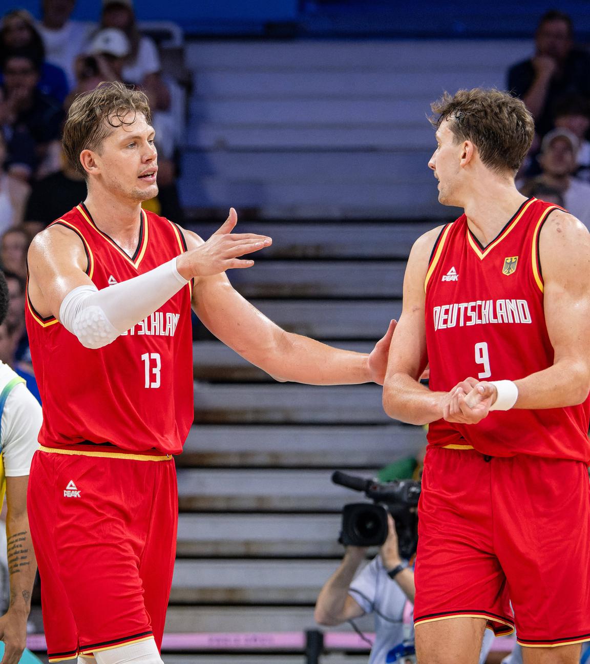 Olympische Spiele Paris 2024: Moritz Wagner (links) und sein Bruder Franz besprechen sich im Vorrundenspiel gegen Brasilien