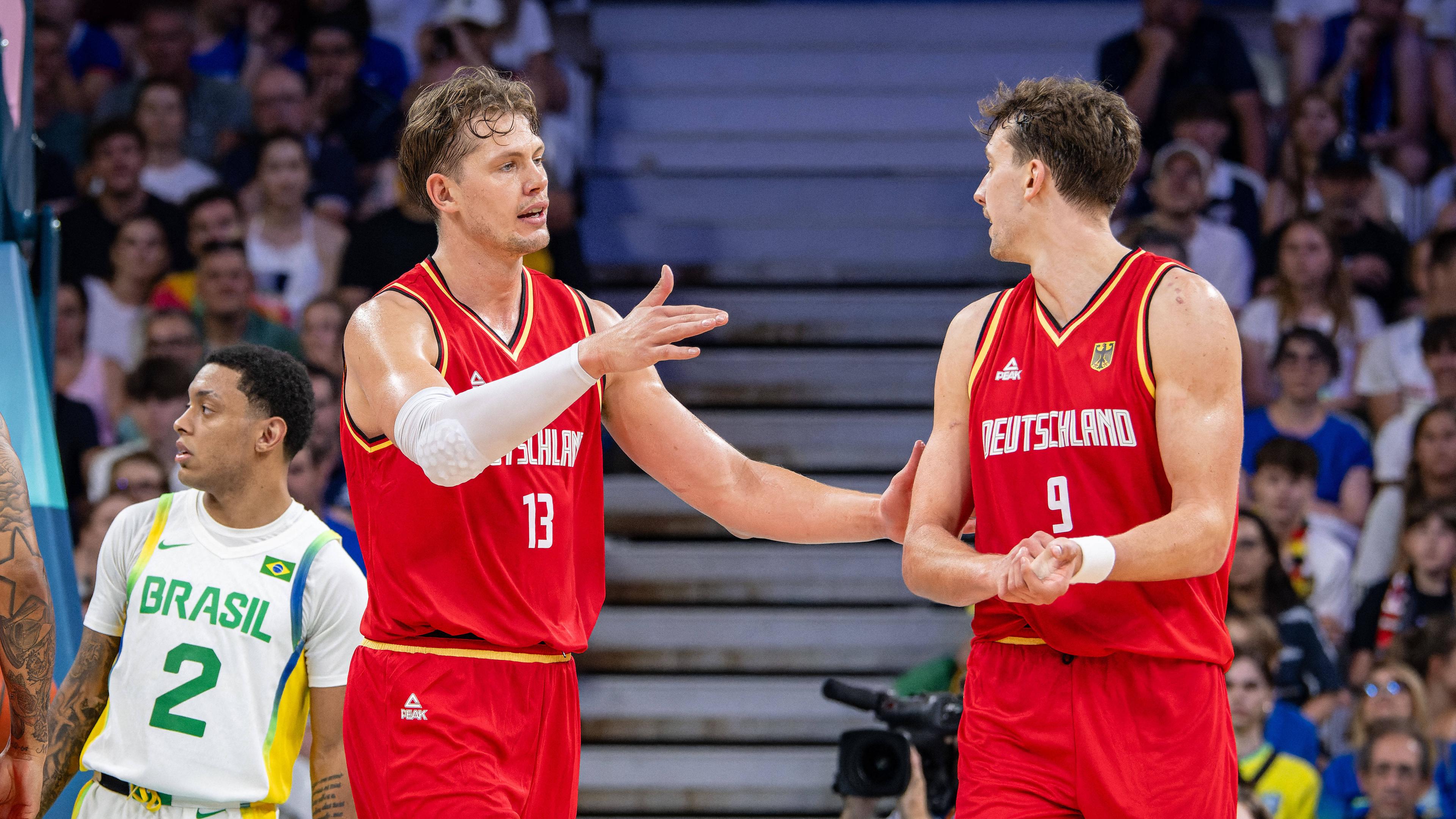 Olympische Spiele Paris 2024: Moritz Wagner (links) und sein Bruder Franz besprechen sich im Vorrundenspiel gegen Brasilien