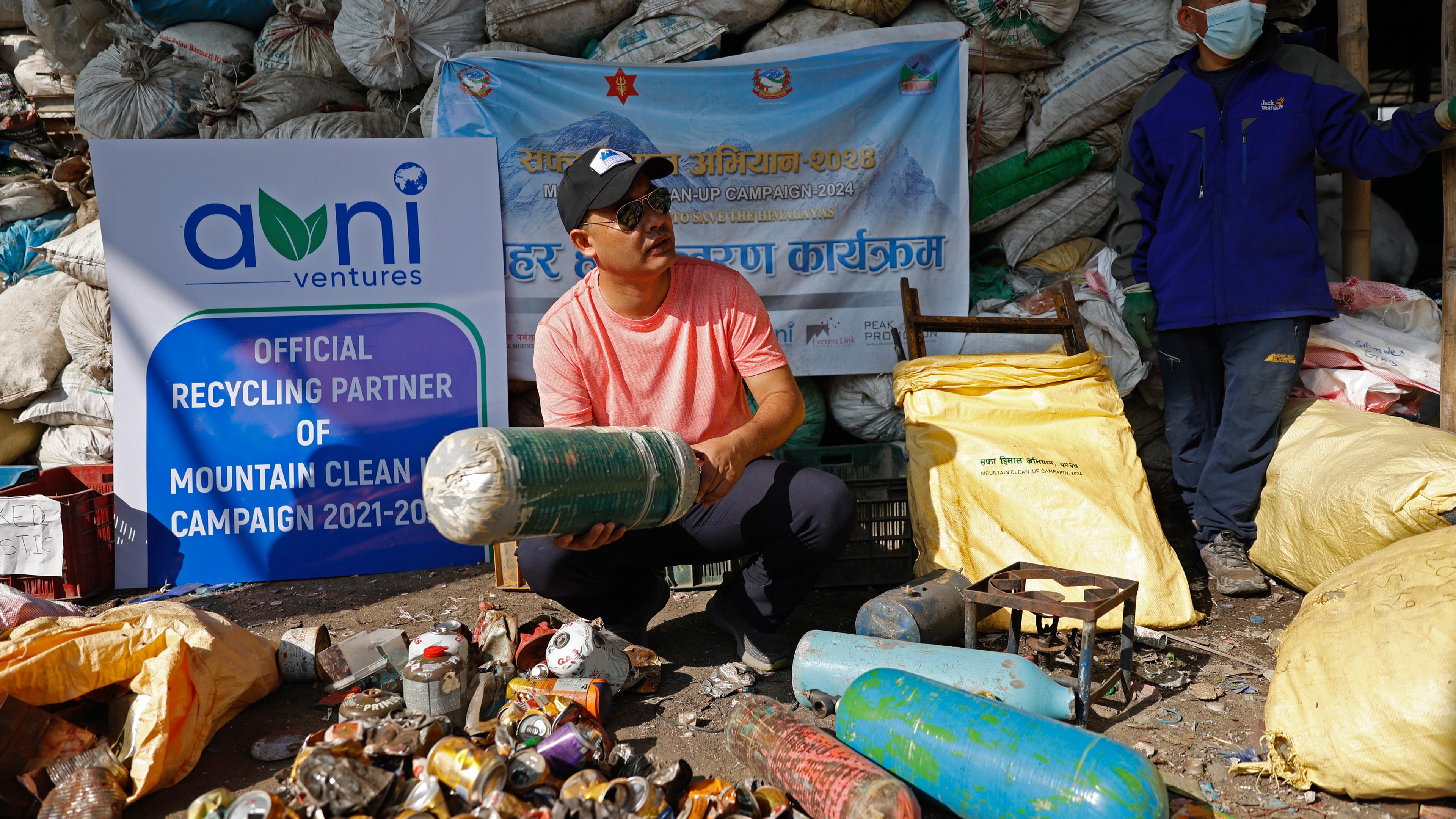 Nepal, Kathmandu: Sushil Khadga von Agni Ventures, einer Agentur, die sich um wiederverwertbare Abfälle kümmert, überprüft eine gebrauchte Sauerstoffflasche, die auf dem Weg zum Mount Everest gesammelt wurde, bevor sie in der Anlage recycelt wird.