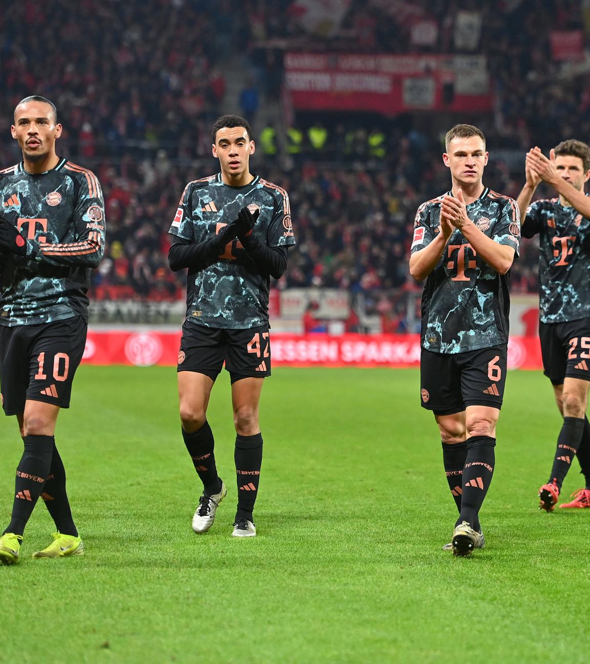 Leroy Sane, Jamal Musiala, Joshua Kimmich und Thomas Müller (von links) klatschen den Bayern-Fans zu nach der 1:2-Niederlage am 14.12.24 in Mainz.