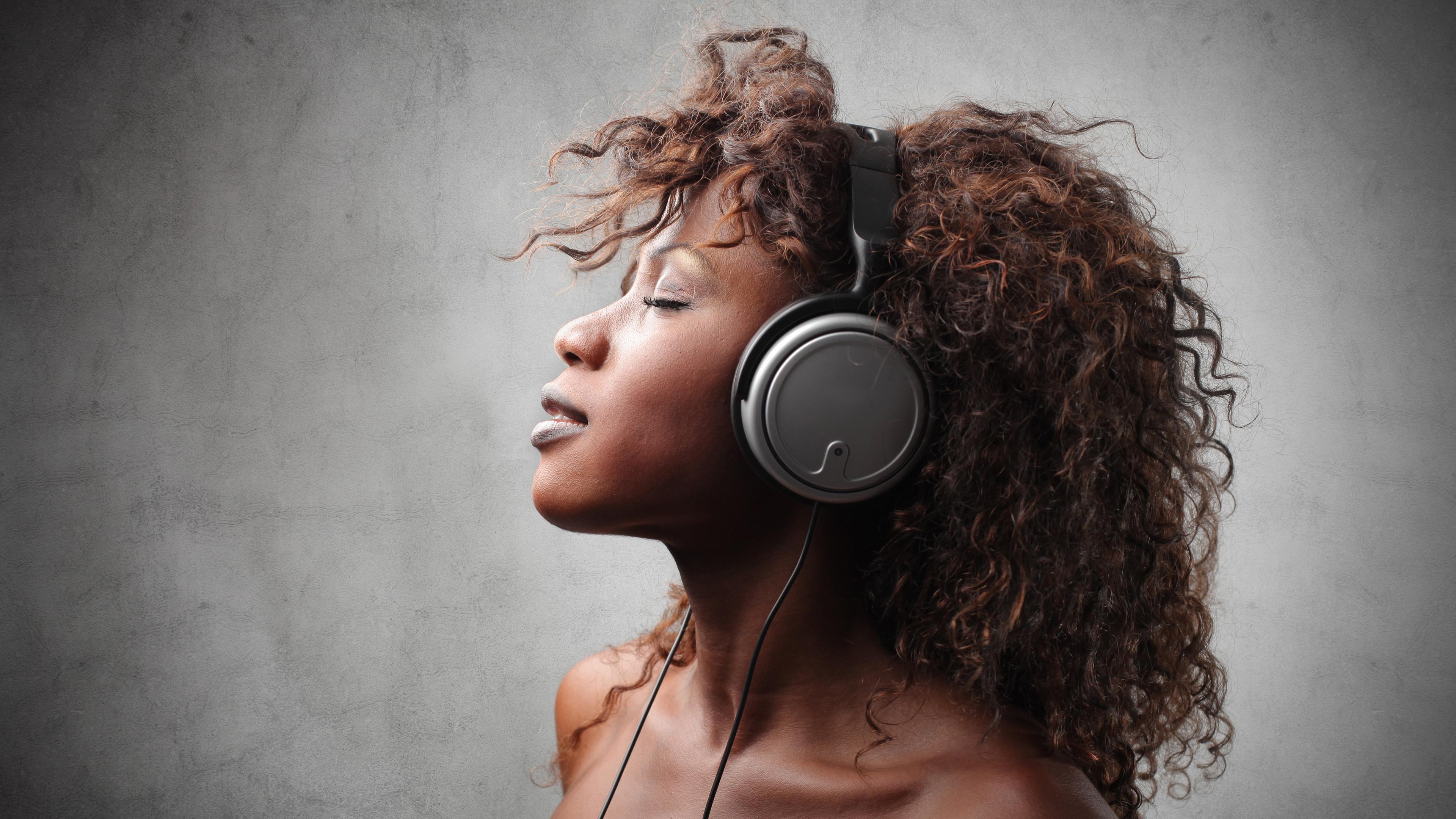 Junge schwarze Frau hört Musik mit Kopfhörer