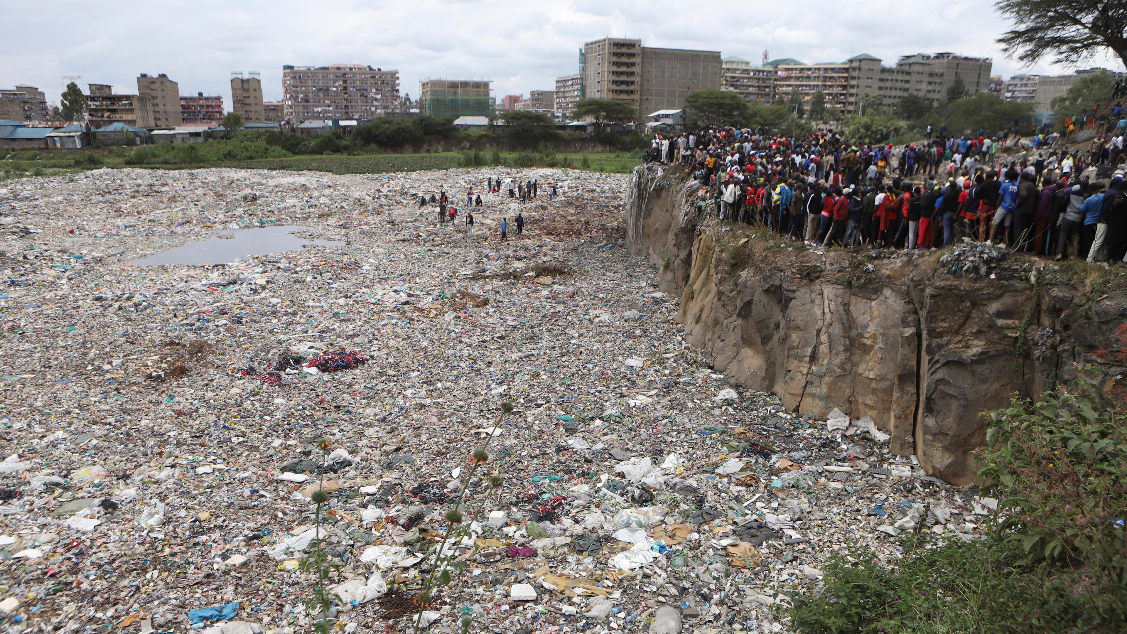Kenia, Nairobi: Menschen beobachten vom Rand eines Steinbruchs aus, in dem menschliche Überreste im Gebiet Mukuru kwa Njenga gefunden wurden.