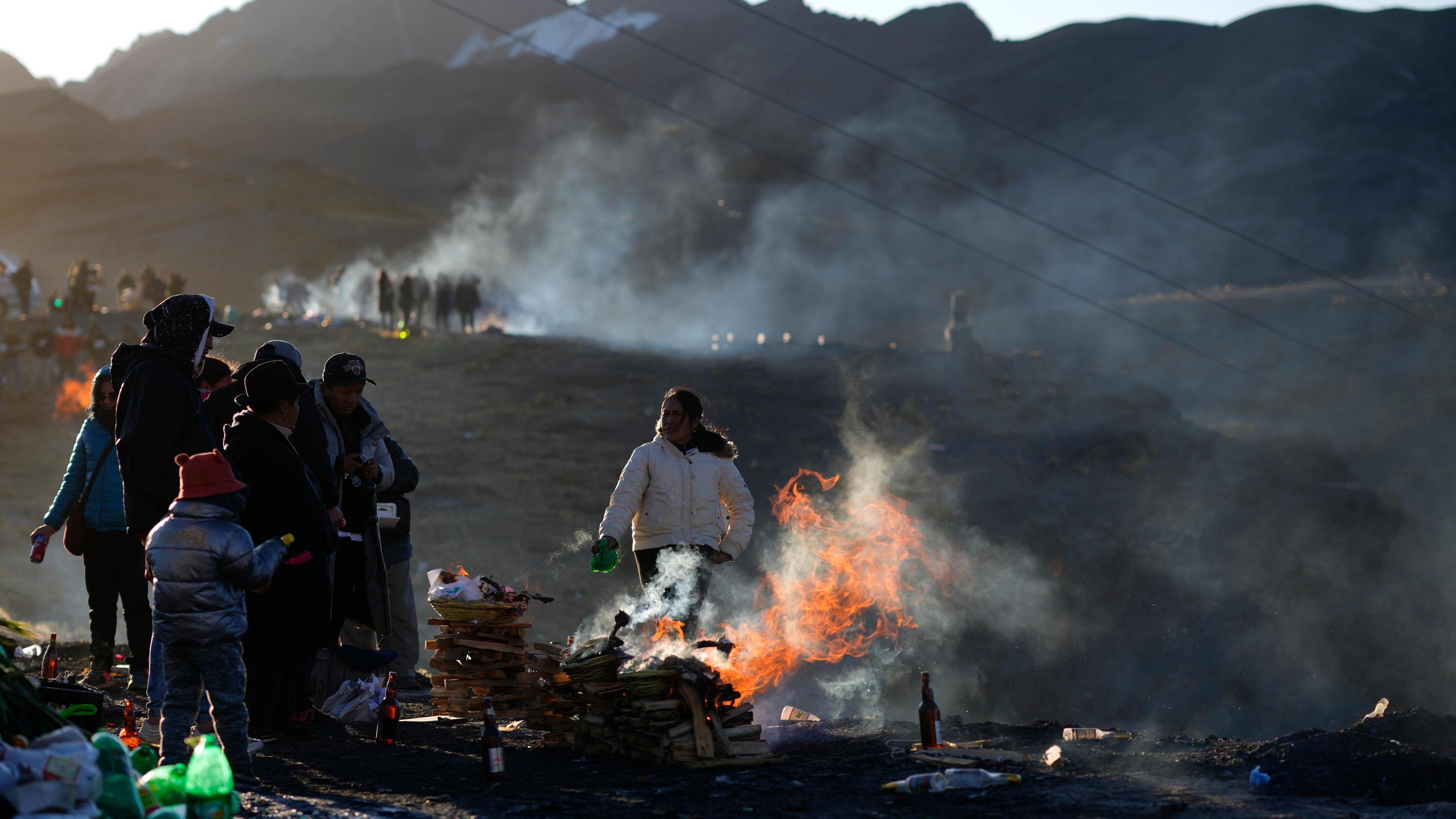 Menschen verbrennen Opfergaben zu Ehren der Pachamama auf einem als heilig geltenden Berg am Stadtrand von La Paz in Bolivien