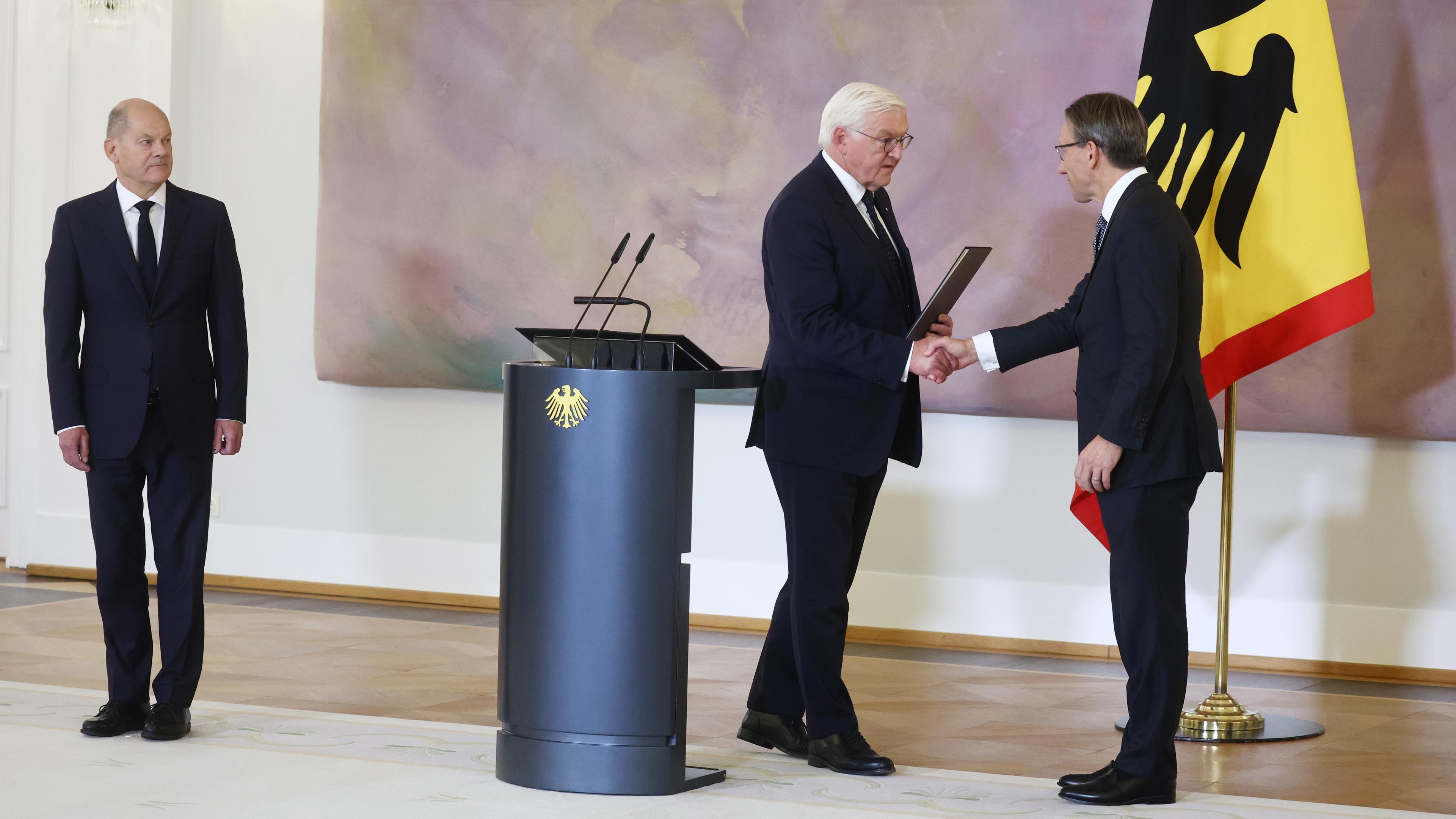 Jörd Kukies (rechts) schüttelt die Hand von Bundespräsident Frank-Walter Steinmeier und erhält seine Ernennungsurkunde.