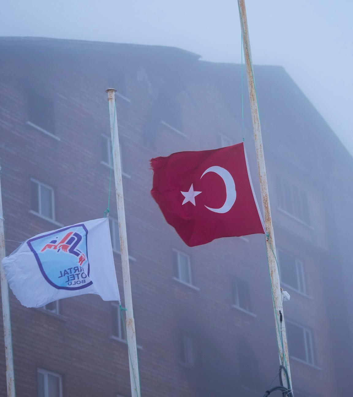 Flaggen auf  Halbmast, im Hintergrund das Hotel