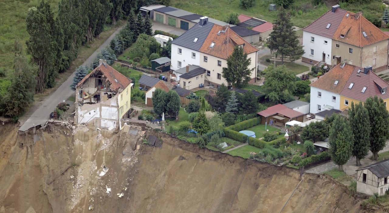 Beim Erdrutsch in Nachterstedt ist ein steiler Abhang vor mehreren Häusern entstanden, von einem Haus steht nur noch die Hälfte.