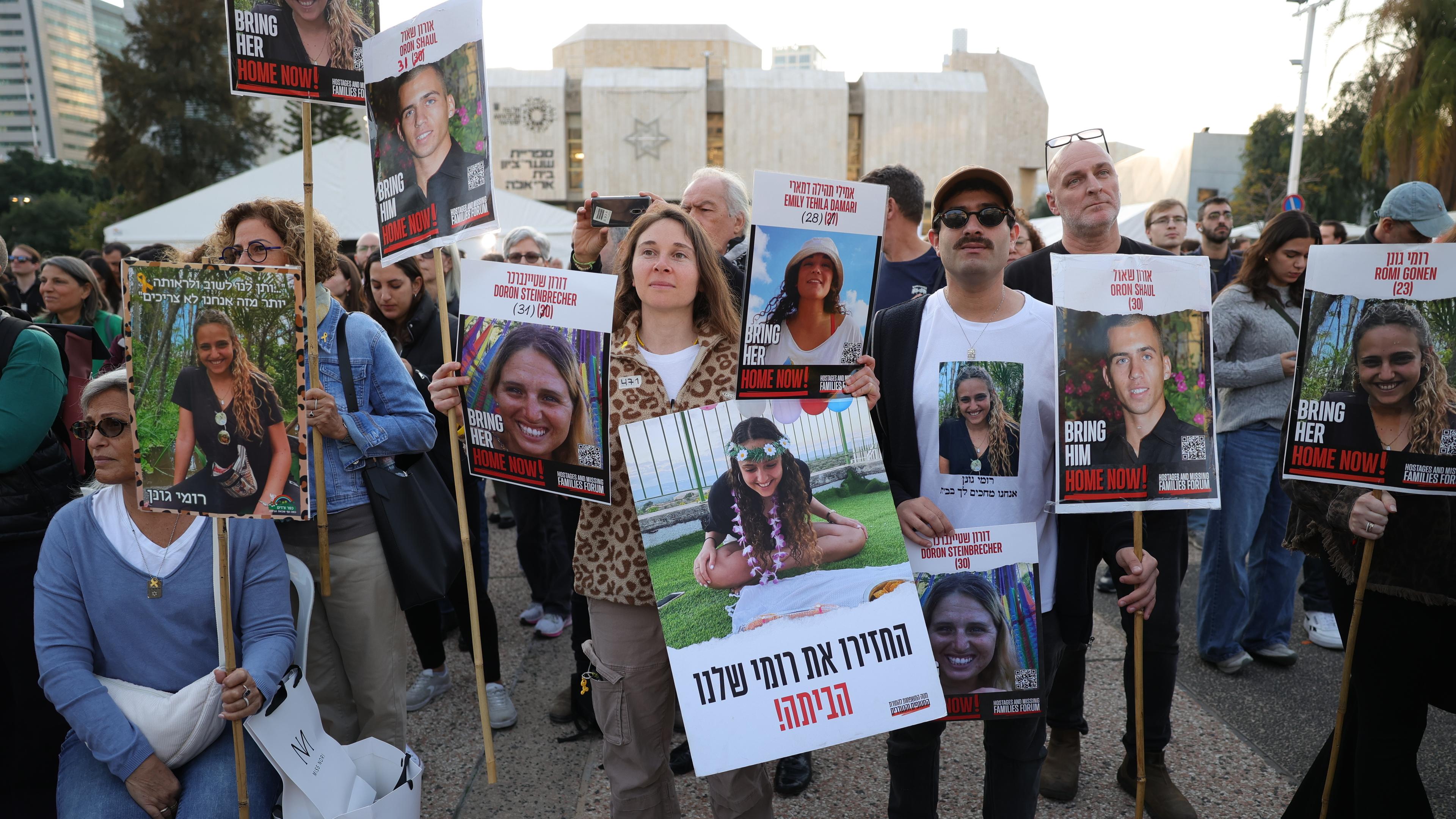 Menschen sehen einen Live-Stream auf einem Großbildschirm, der über die Freilassung der drei israelischen weiblichen Geiseln Romi Gonen, Emily Damari und Doron Steinbrecher berichtet, die von der Hamas an das Rote Kreuz übergeben wurden, auf dem Geiselplatz vor dem Militärstützpunkt Kirya, als die Waffenruhe in Gaza in Kraft trat, in Tel Aviv, Israel, am 19. Januar 2025.