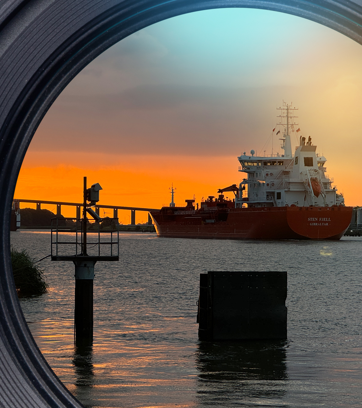 Das Frachtschiff "Sten Fjell" fährt im Abendrot in Richtung Hochbrücke Brunsbüttel.