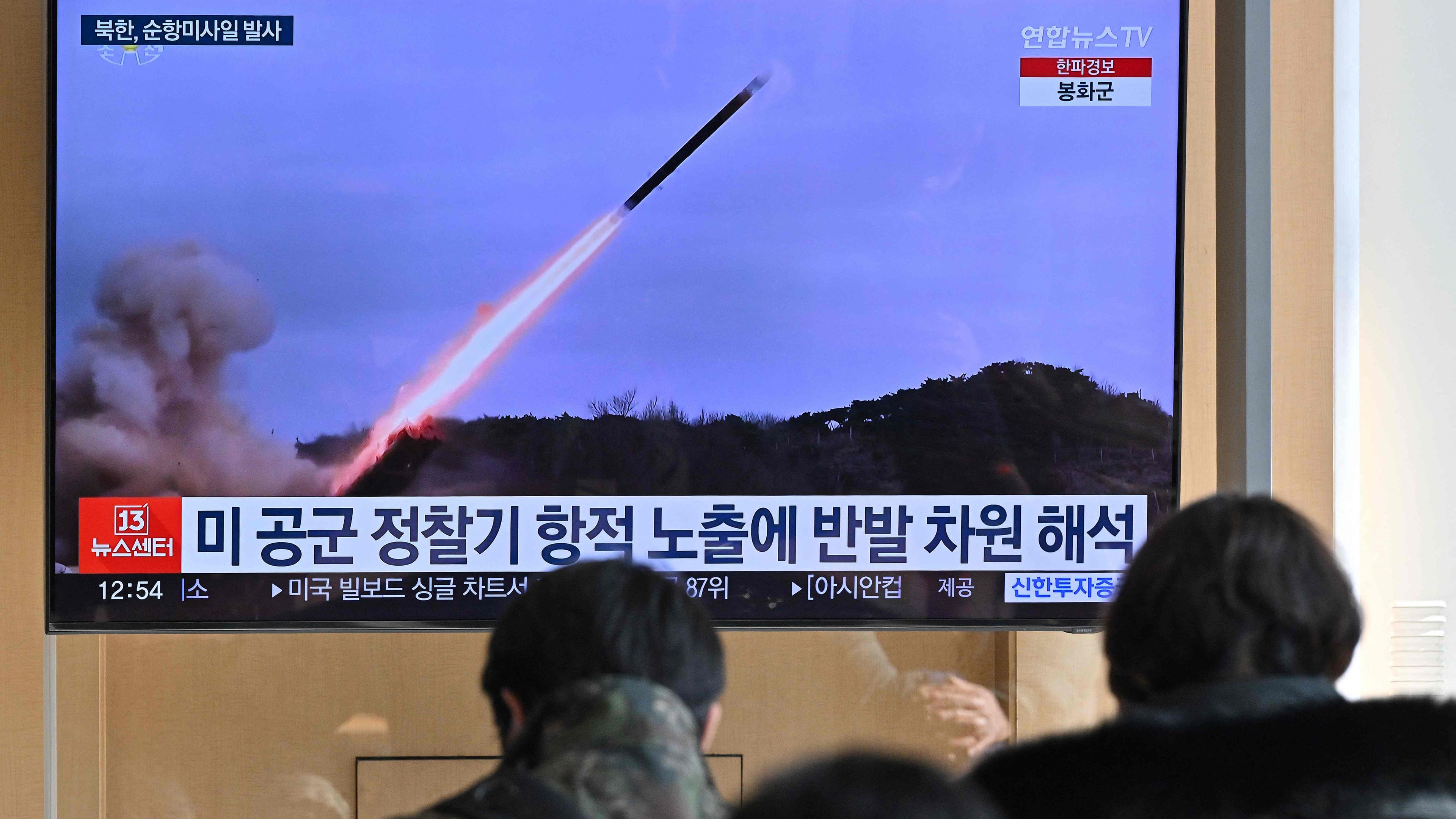 Menschen schauen auf einen Fernsehbildschirm in Seoul (Südkorea), auf dem ein Raketenabschuss zu sehen ist.