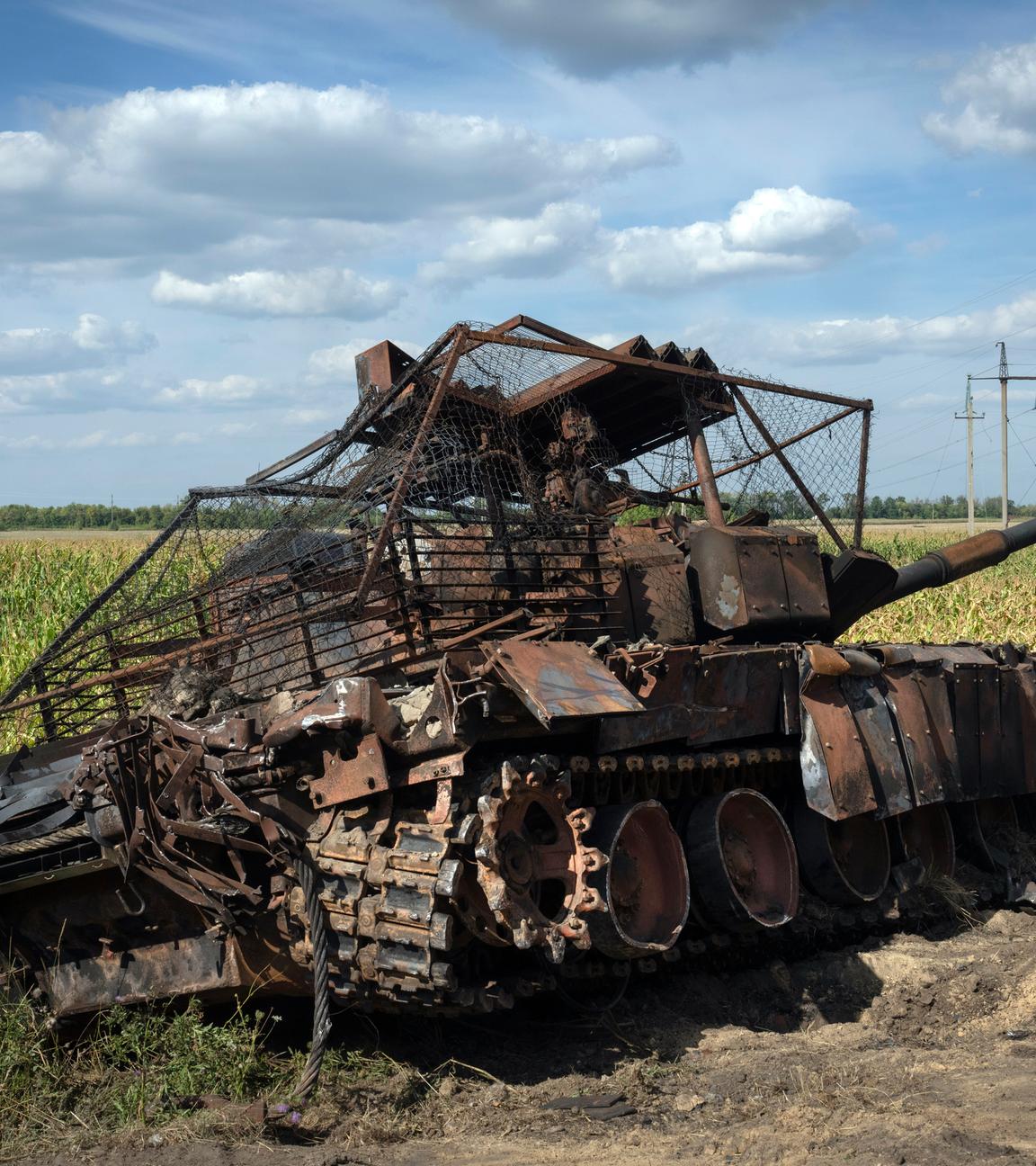 Ein zerstörter russischer Panzer liegt am Straßenrand.