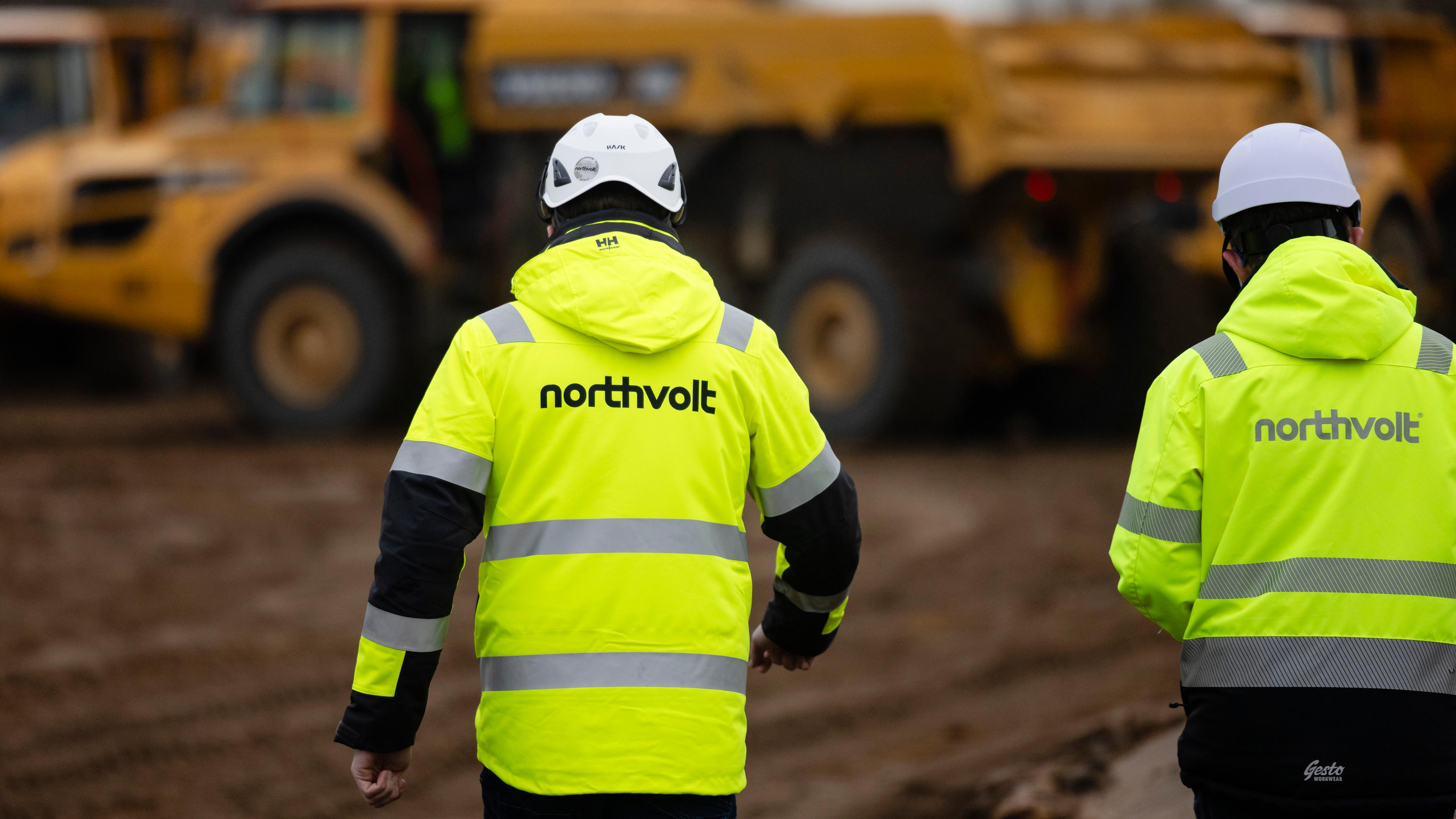 Zwei Mitarbeiter der Firma Northvolt gehen über eine Baustelle im Kreis Dithmarschen.
