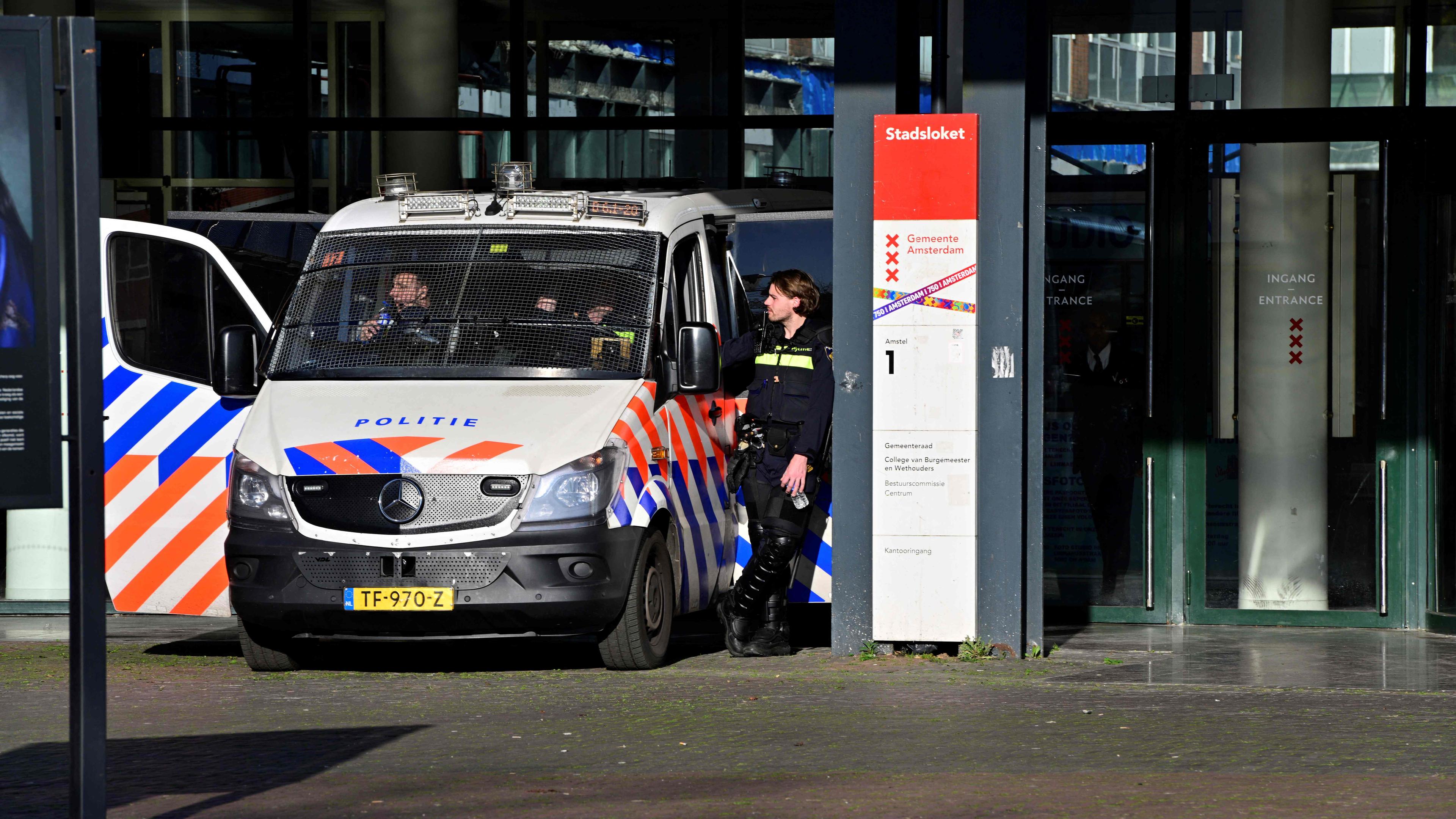 Polizisten stehen im November 2024 vor dem Amsterdamer Stadtrat, während der Bürgermeister von Amsterdam auf einer Dringlichkeitssitzung spricht.