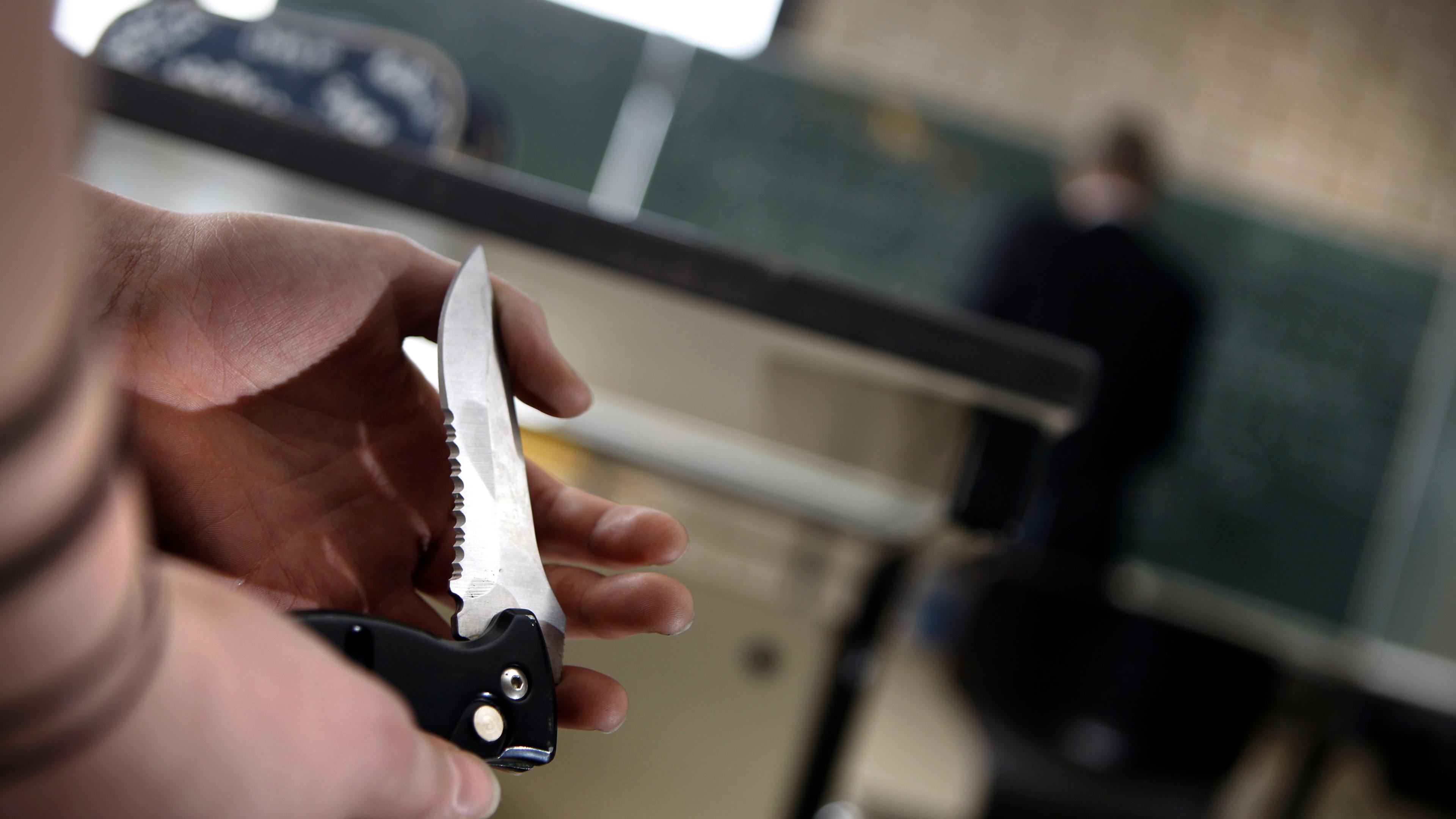 Nordrhein-Westfalen, Kerpen: Eine Schülerin zeigt an einem Gymnasium während des Unterrichts einer Mitschülerin ihr Klappmesser.