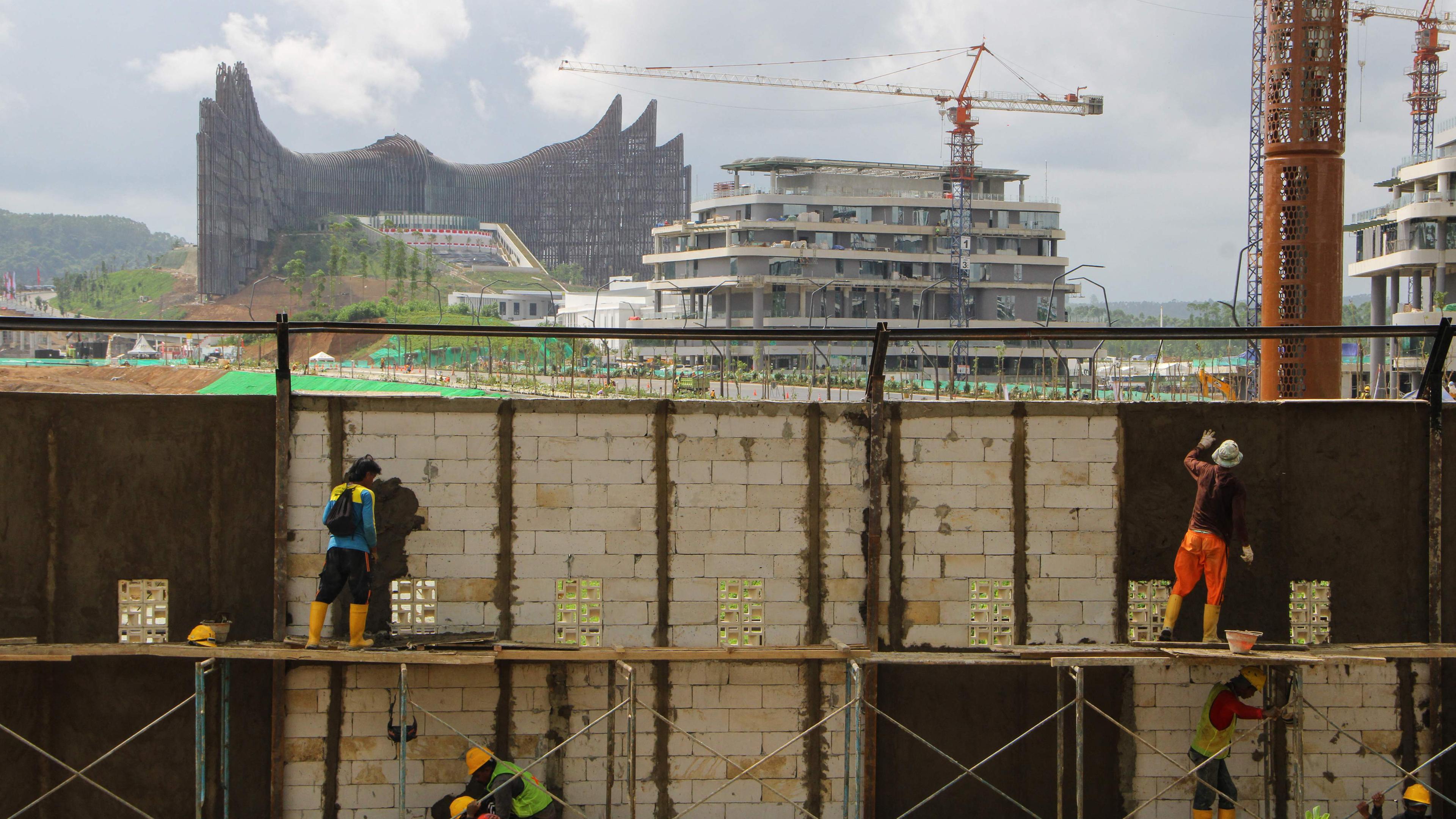 Bauarbeitende arbeiten an einer Mauer vor dem Präsidentenpalast in der neuen Hauptstadt Indonesiens.