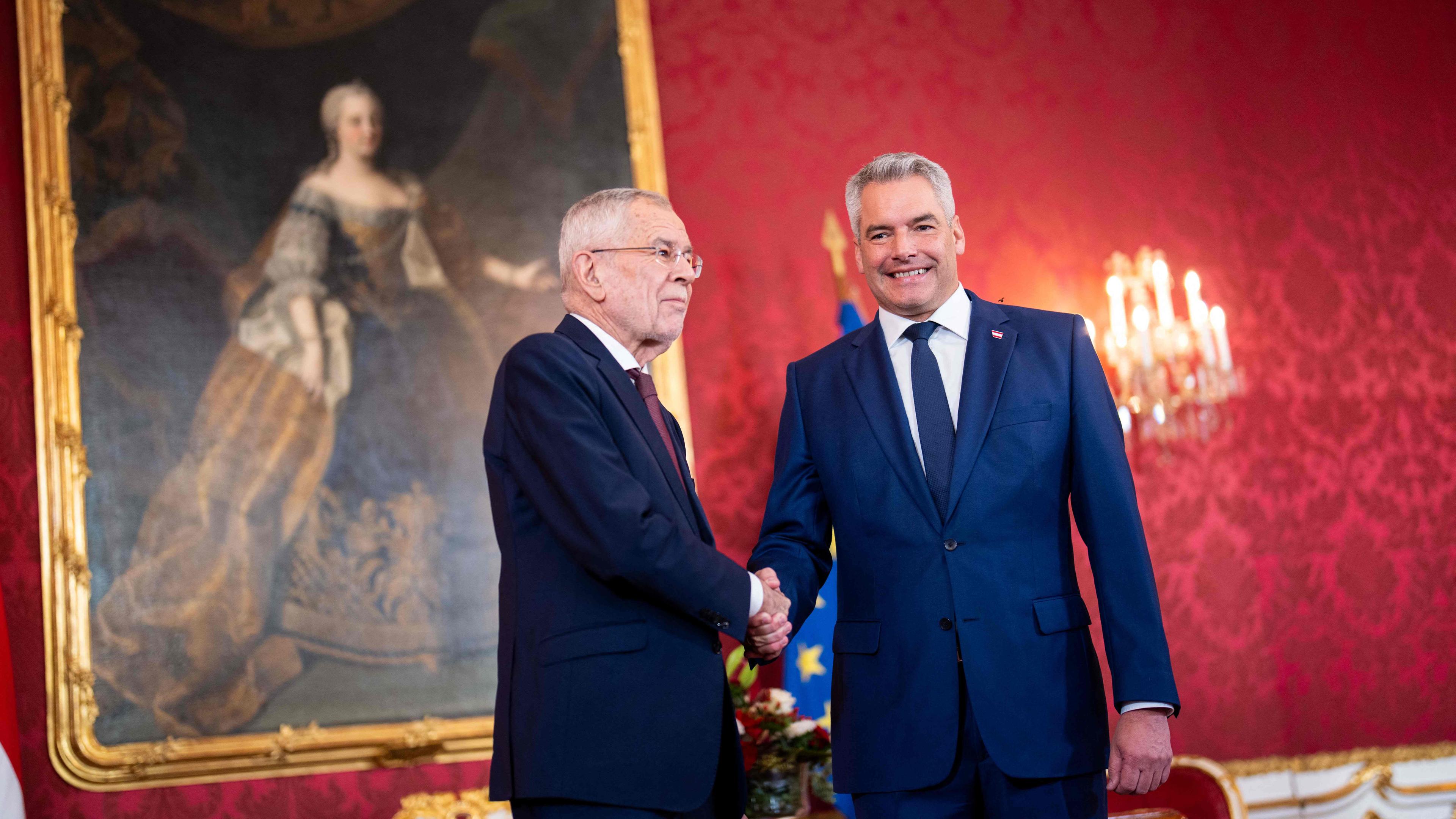 Austrian President Alexander van der Bellen (L) and Austrian Chancellor Karl Nehammer shake hands as they meet at the Presidential Chancellery in Vienna