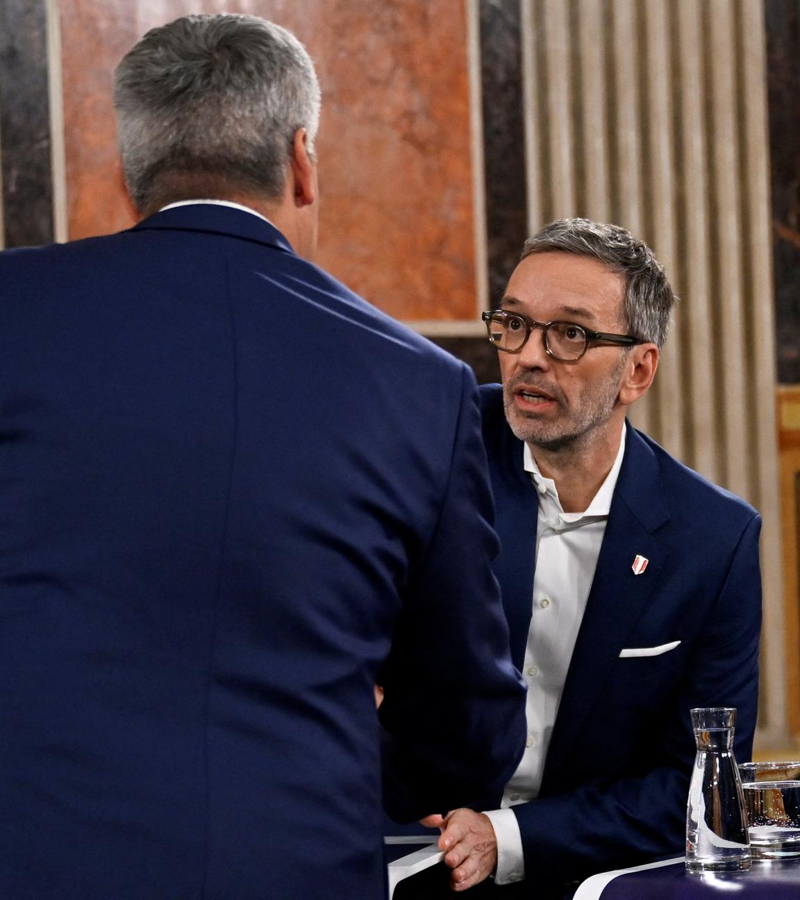 Herbert Kickl (FPÖ) und Karl Nehammer (ÖVP) geben sich die Hand nach den ersten Hochrechnungen. 