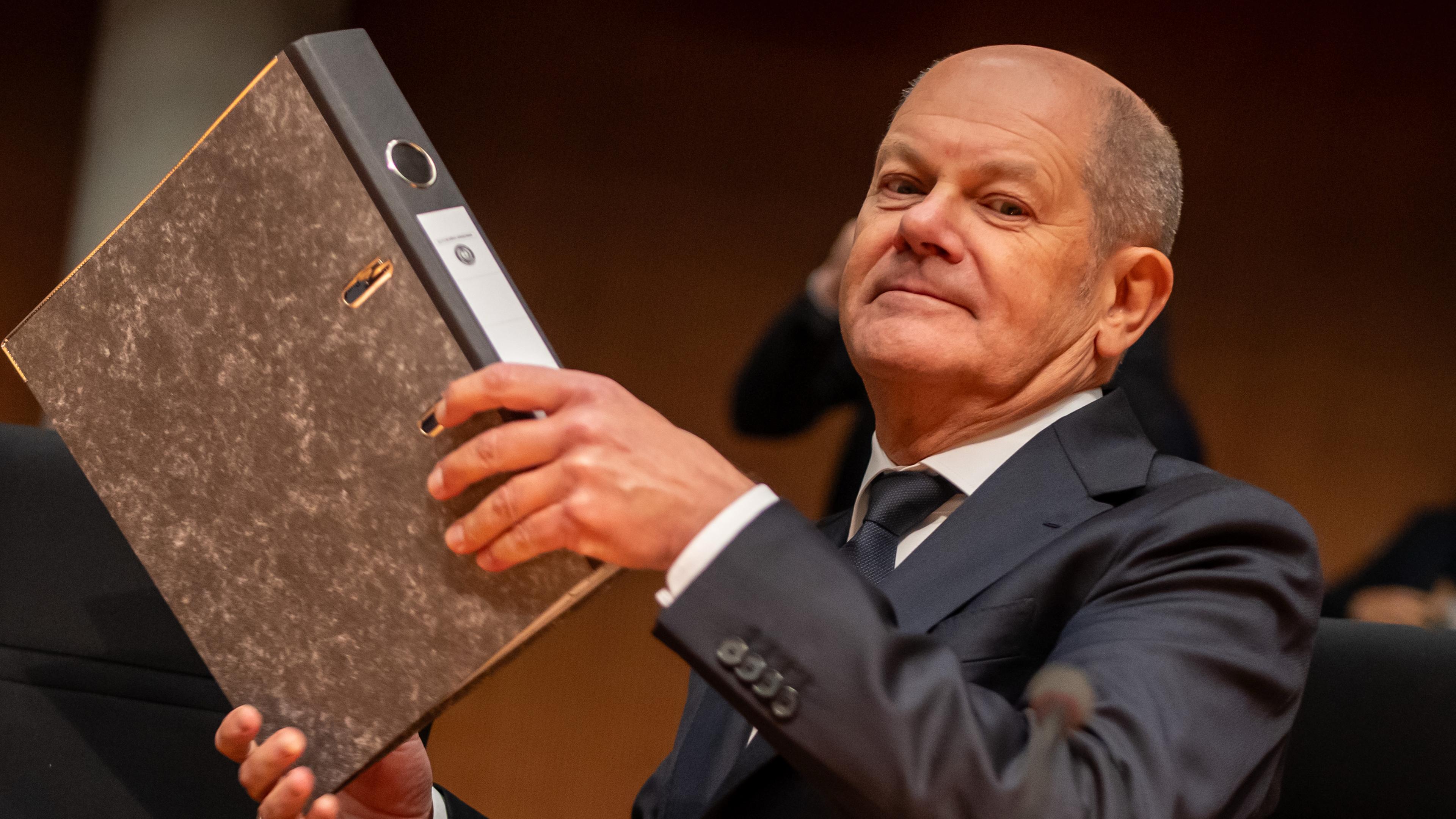 Olaf Scholz mit Aktenordner in der Hand