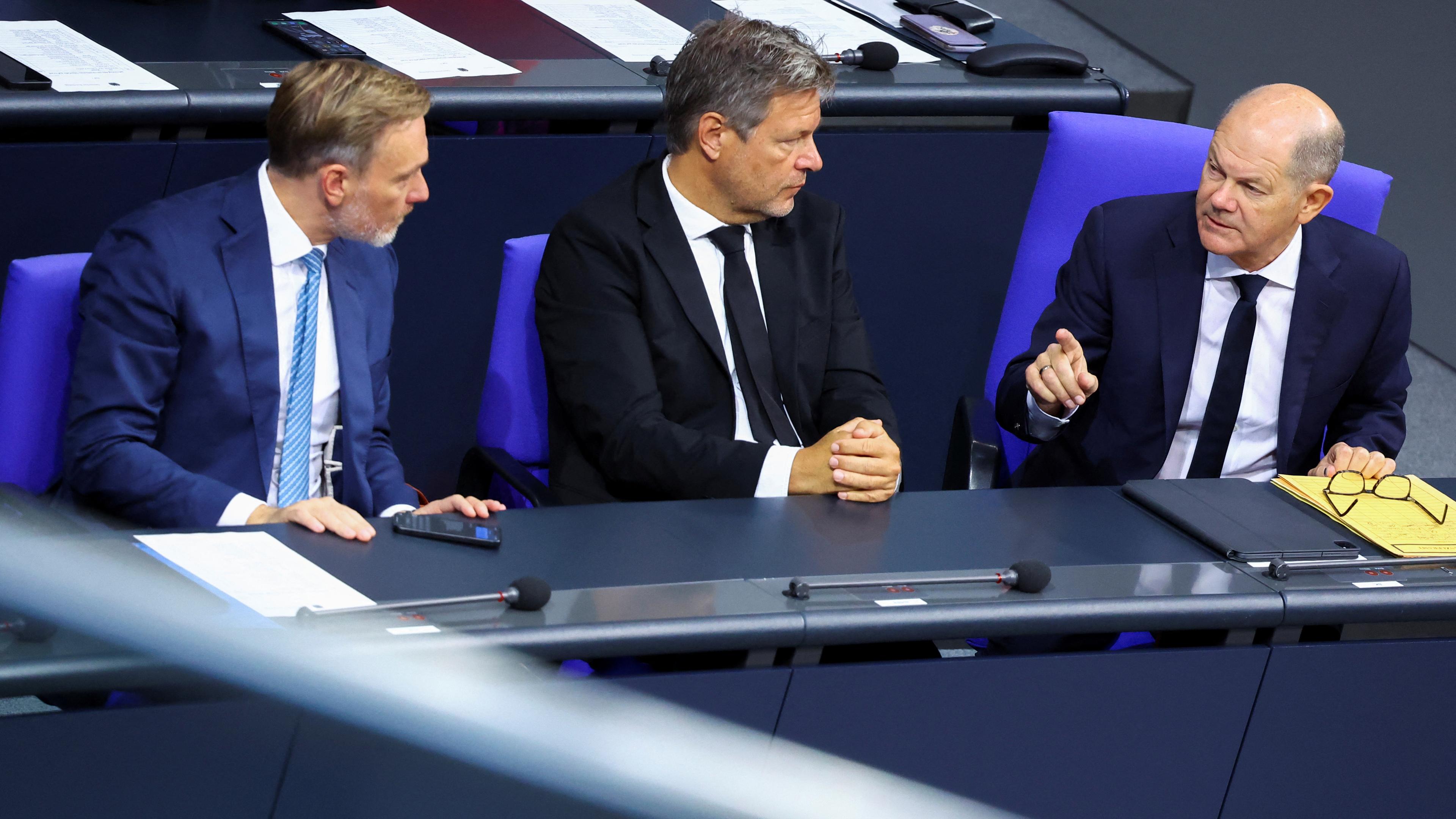 Olaf Scholz, Robert Habeck und Christian Lindner sprechen während einer Sitzung des Bundestages in Berlin, 10.10.2024.