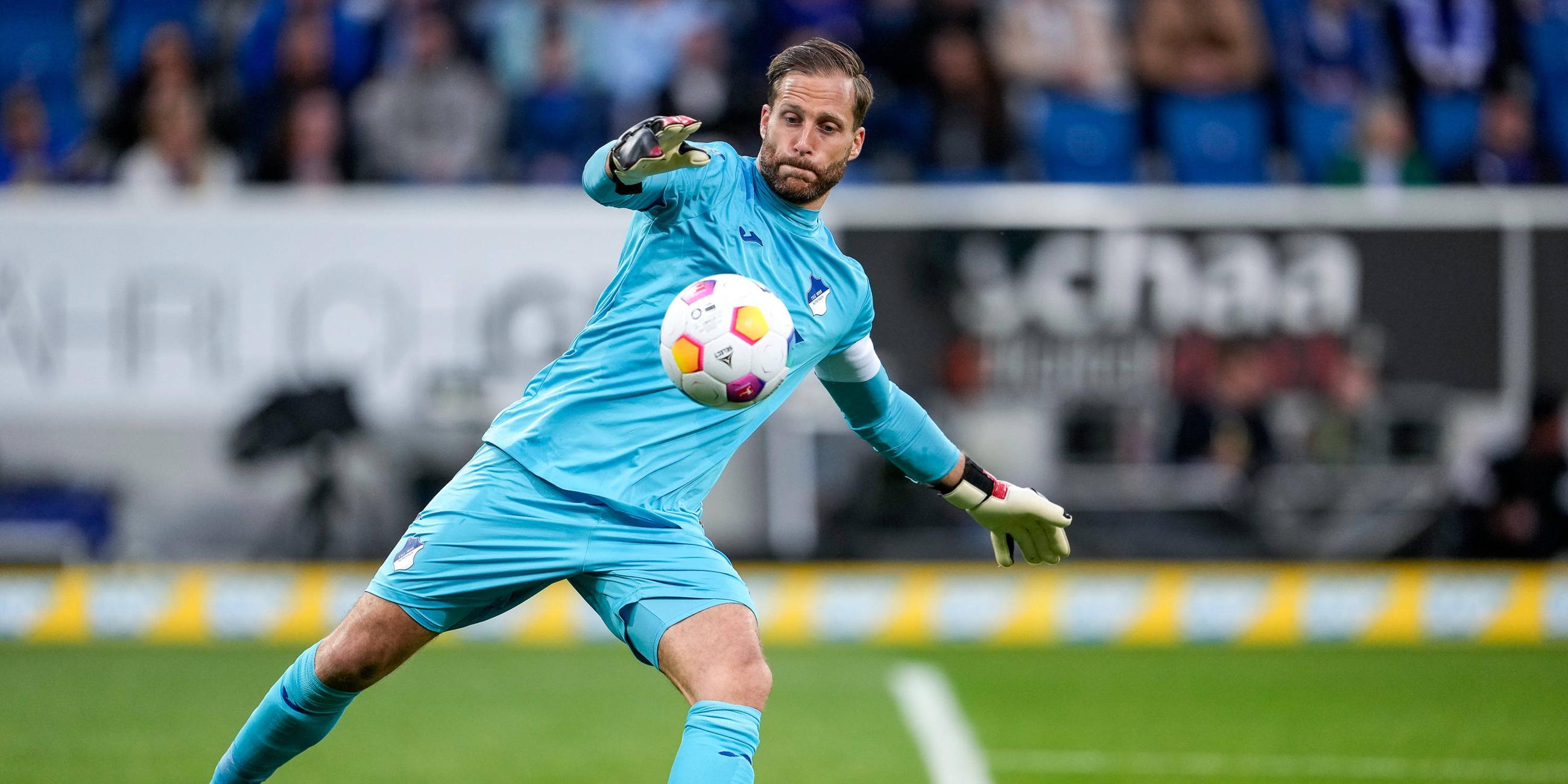 Der Fußballspieler Oliver Baumann auf dem Feld mit einem Ball.