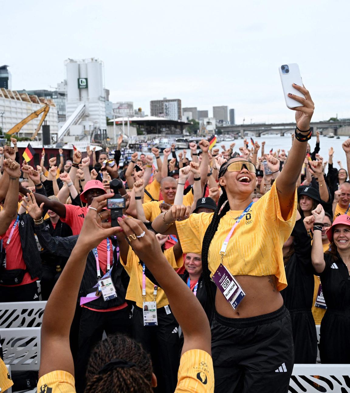 Satou Sabally aus Deutschland macht vor der Eröffnungszeremonie ein Selfie mit Athleten auf dem Boot.