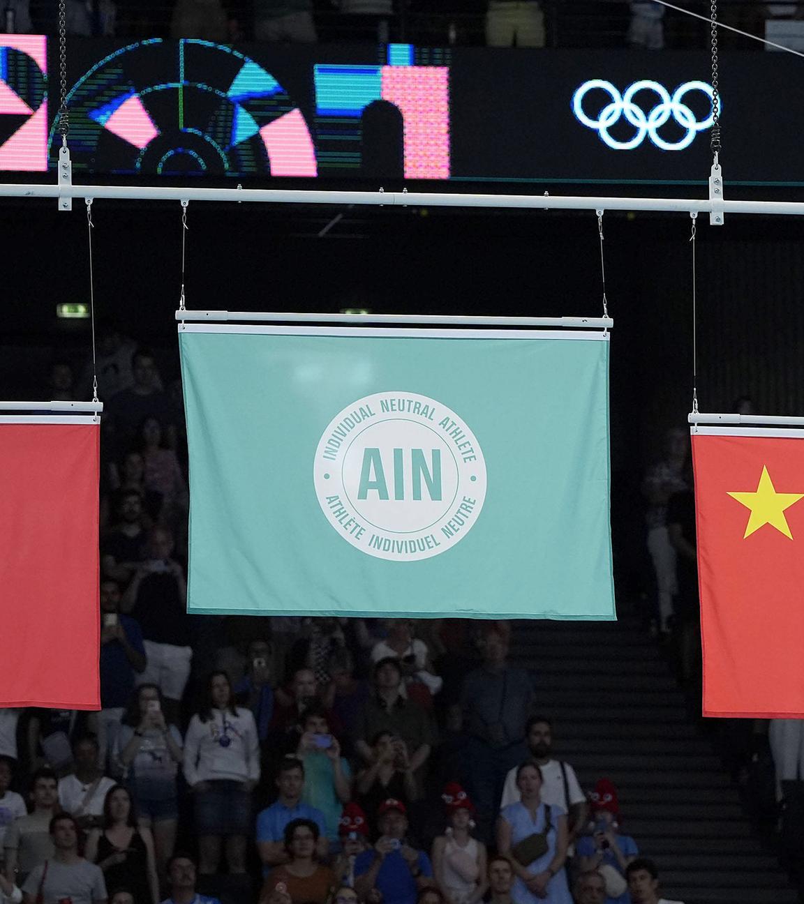 Eine Flagge, die einzelne neutrale Athleten repräsentiert (M.), wird gehisst, nachdem Ivan Litvinovich aus Weißrussland am 02.08.2024 in der Bercy Arena in Paris den Trampolinturnwettbewerb der Männer bei den Olympischen Spielen in Paris gewonnen hat