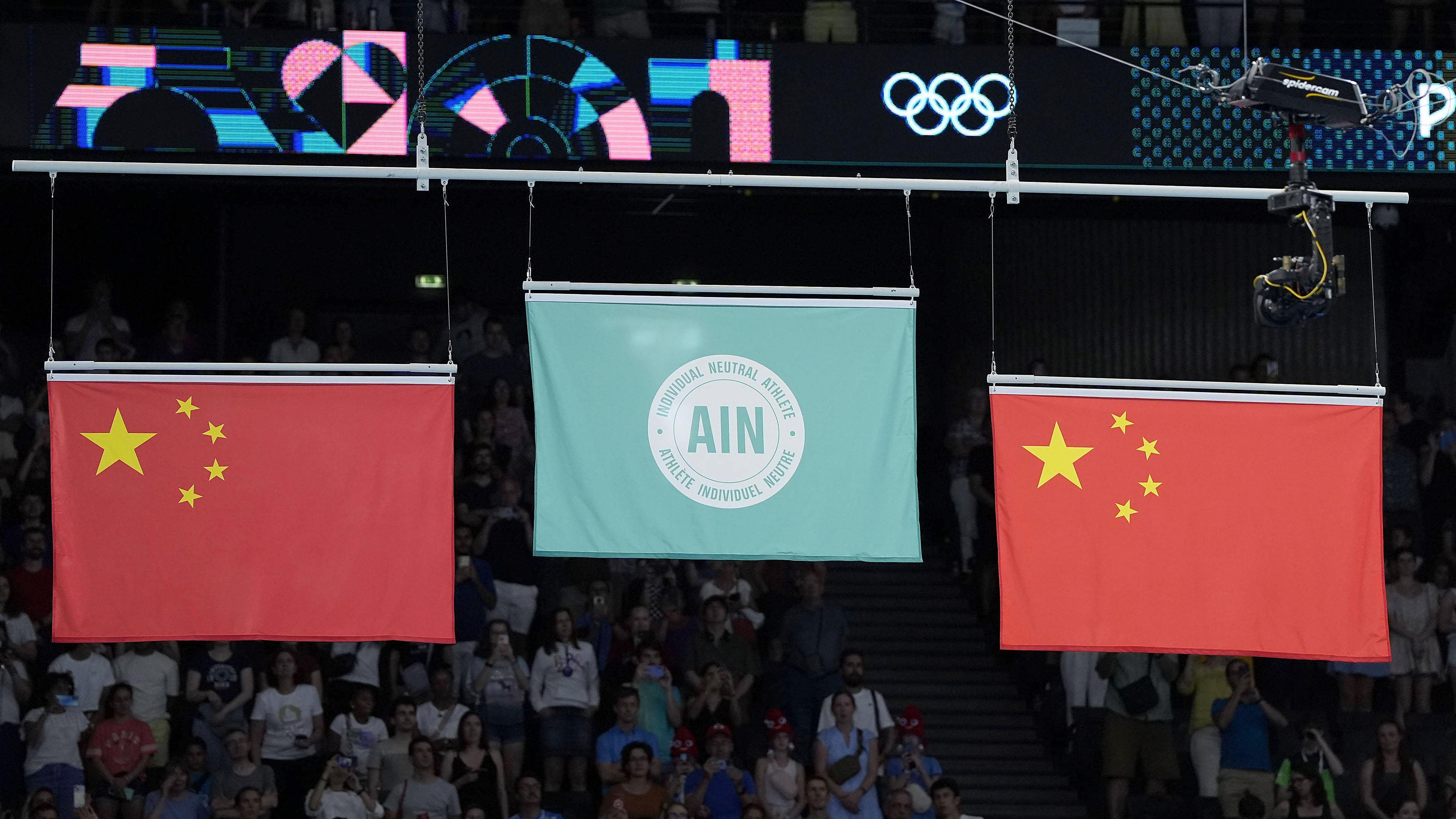 Eine Flagge, die einzelne neutrale Athleten repräsentiert (M.), wird gehisst, nachdem Ivan Litvinovich aus Weißrussland am 02.08.2024 in der Bercy Arena in Paris den Trampolinturnwettbewerb der Männer bei den Olympischen Spielen in Paris gewonnen hat