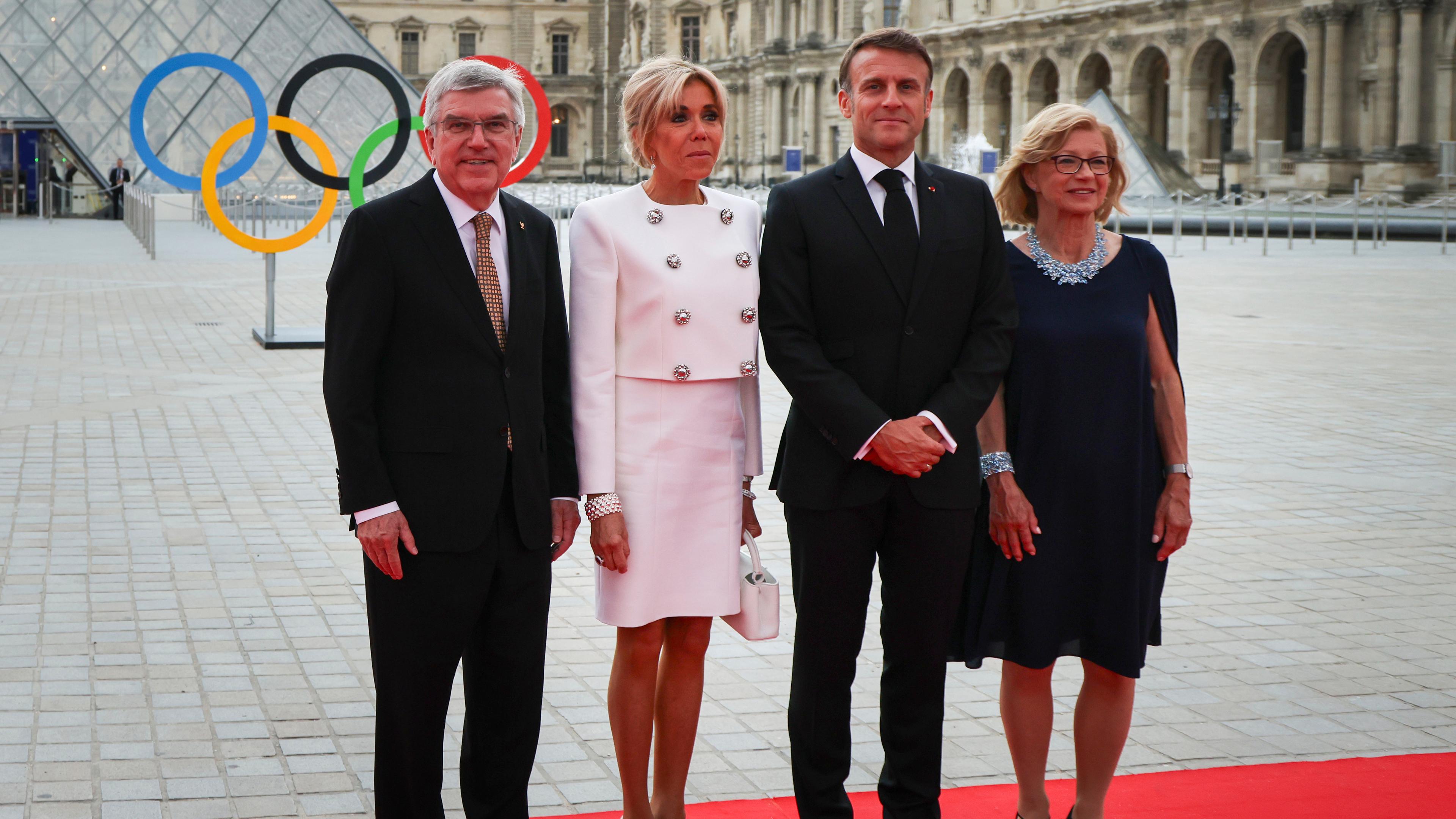 25.07.2024, Frankreich, Paris:  Thomas Bach, Präsident des Internationalen Olympischen Komitees, und seine Frau Claudia Bach, begrüßen den französischen Präsidenten Emmanuel Macron und seine Frau Brigitte Macron.